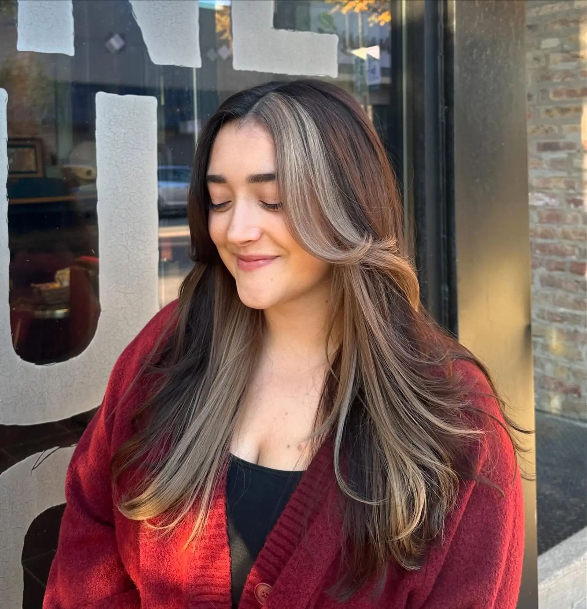 A long layered hairstyle with face-framing layers and a bold money piece. 1