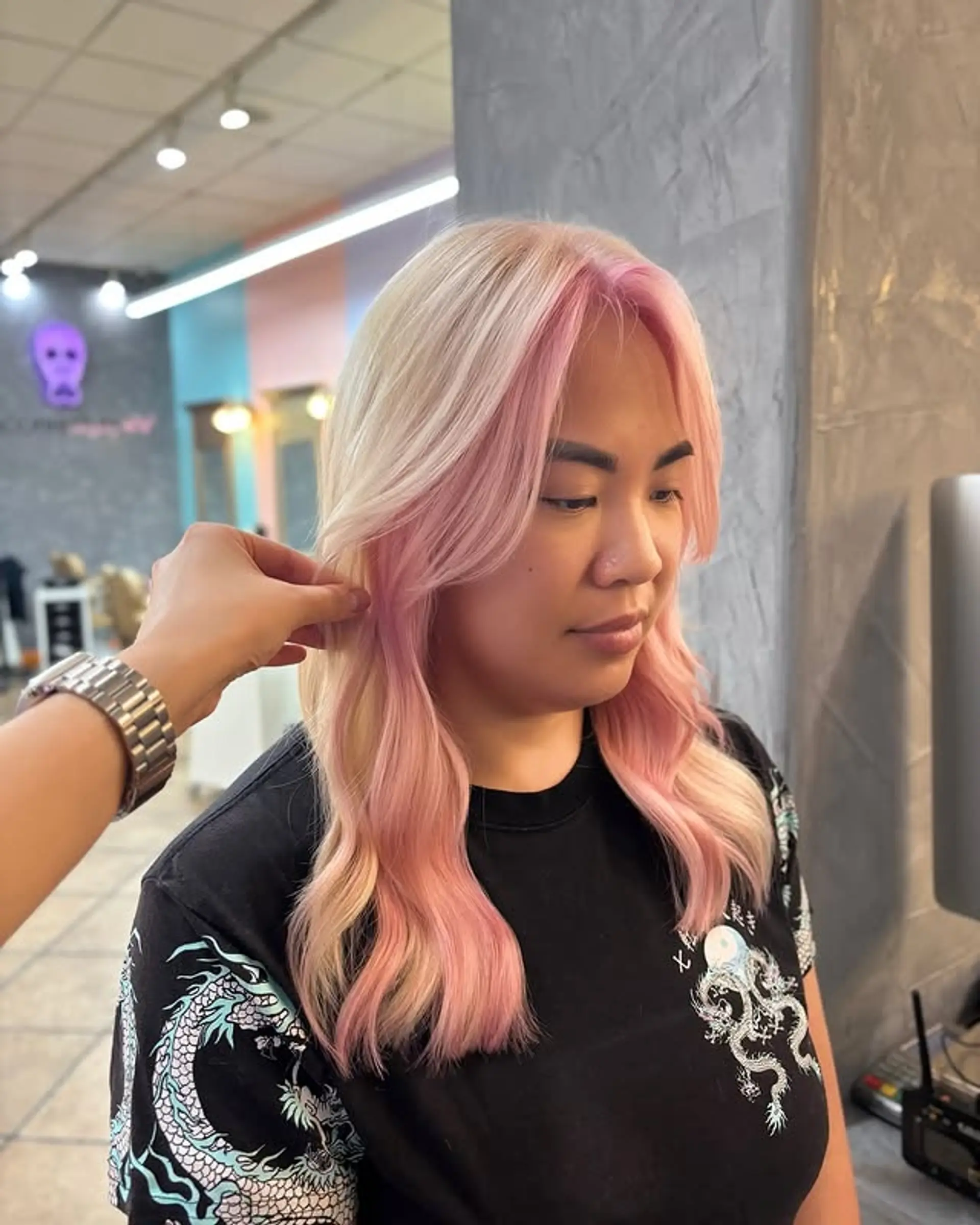 A medium-length wavy hairstyle with blonde hair and pink face-framing highlights. 1