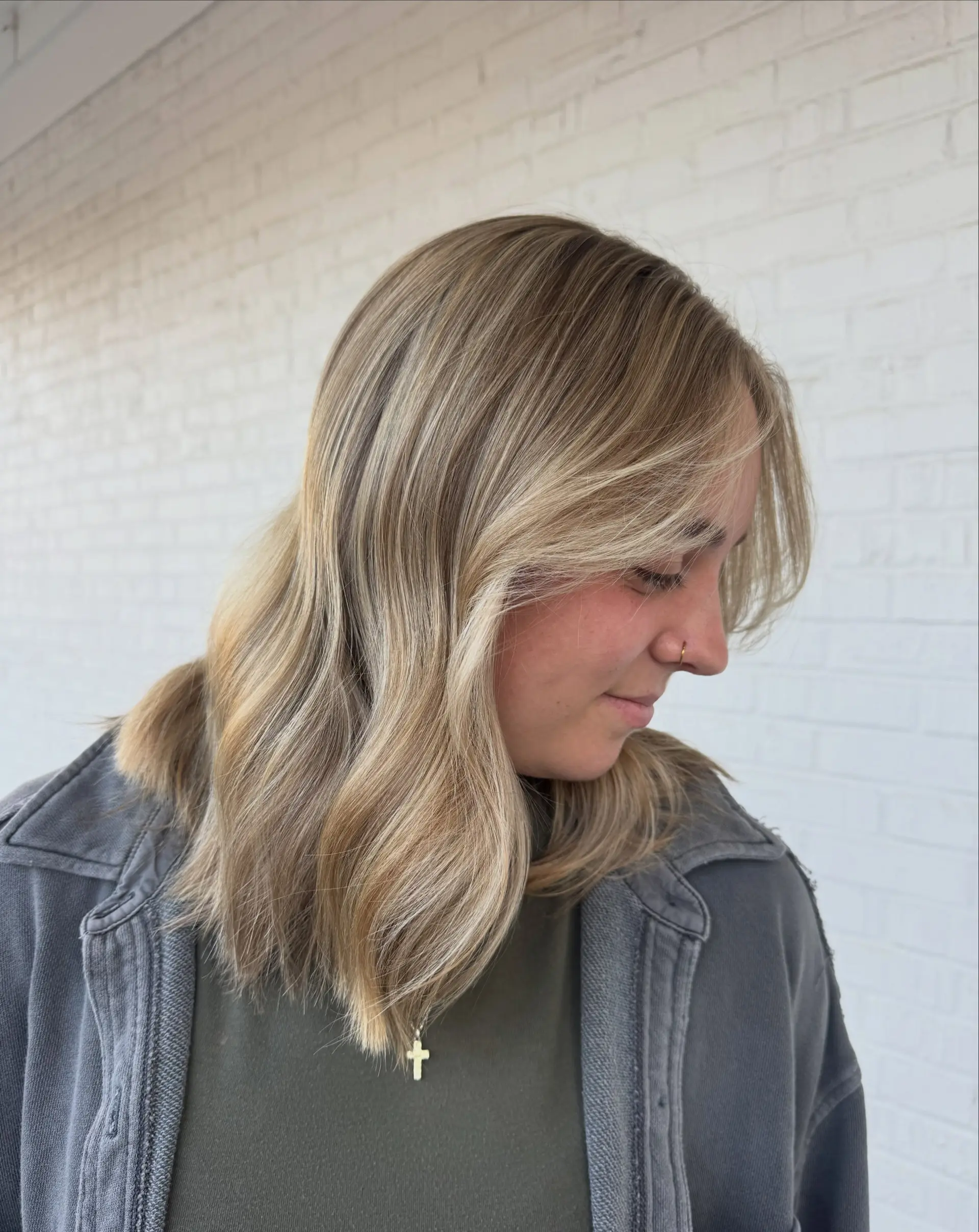 Medium-length vanilla blonde hair featuring soft dimension and face-framing curtain bangs. 1