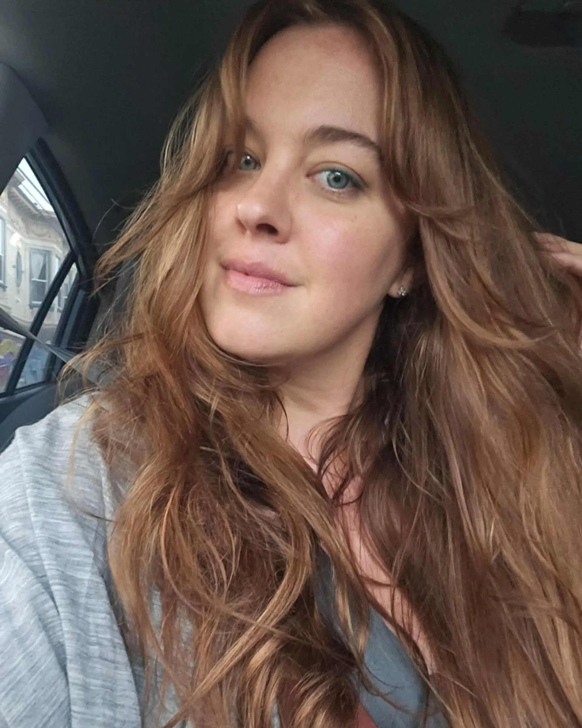 Long copper hair styled in soft, loose waves with face-framing curtain bangs. 1