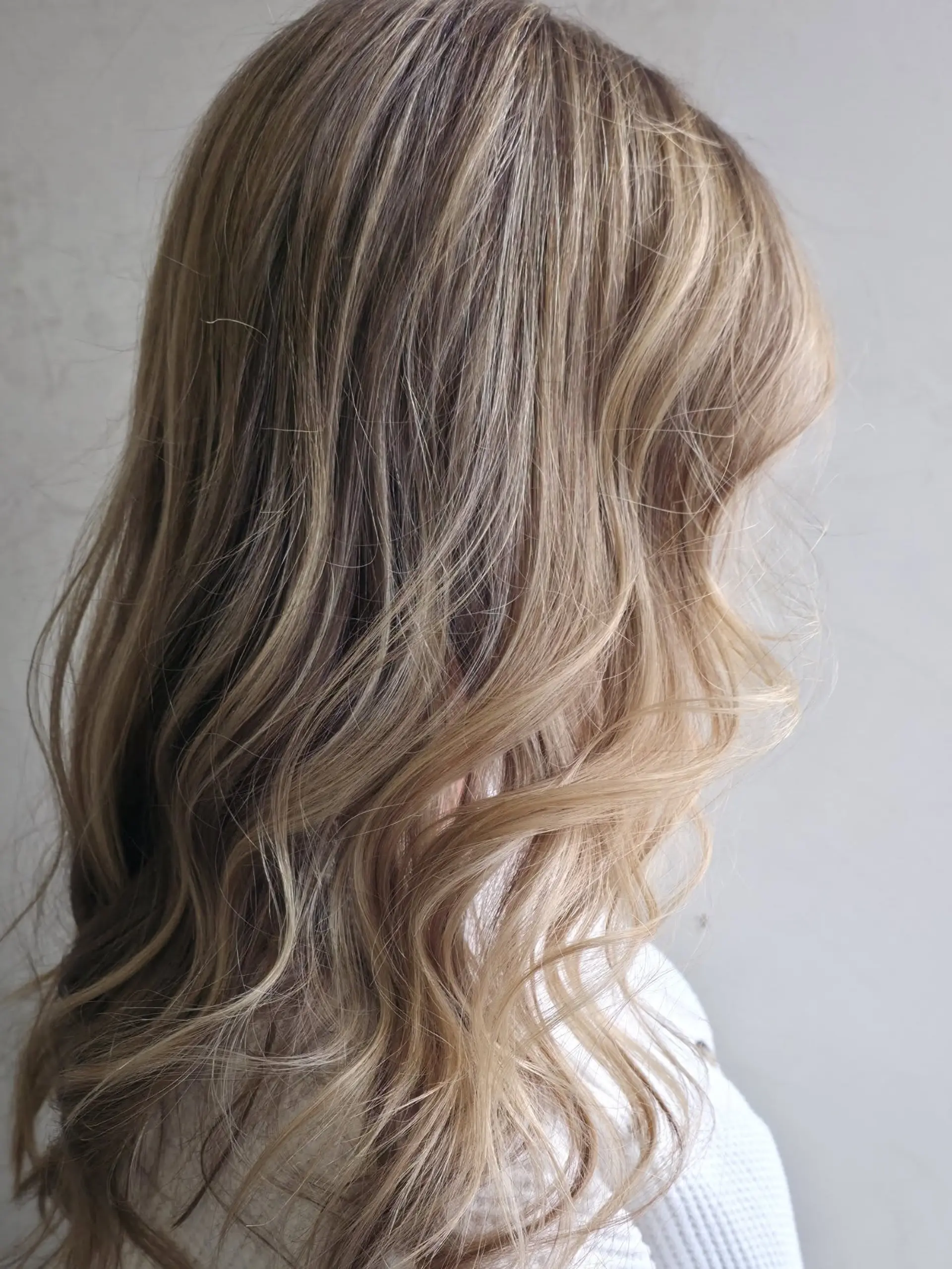 Long hair featuring fine, multi-dimensional blonde highlights styled in loose, natural waves. 1