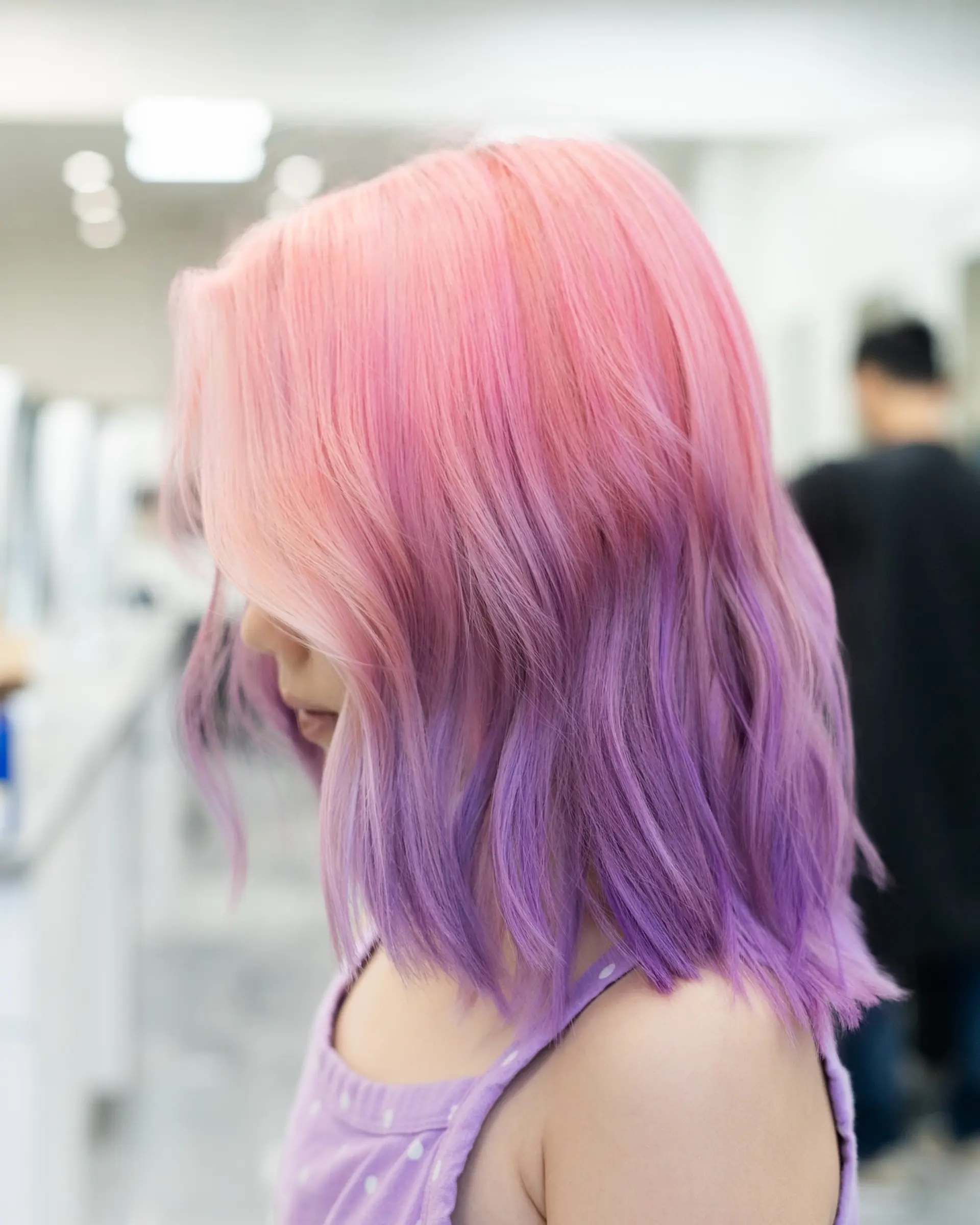 A medium-length textured bob with a two-tone pastel color melt blending from soft pink into vibrant lavender purple. 1