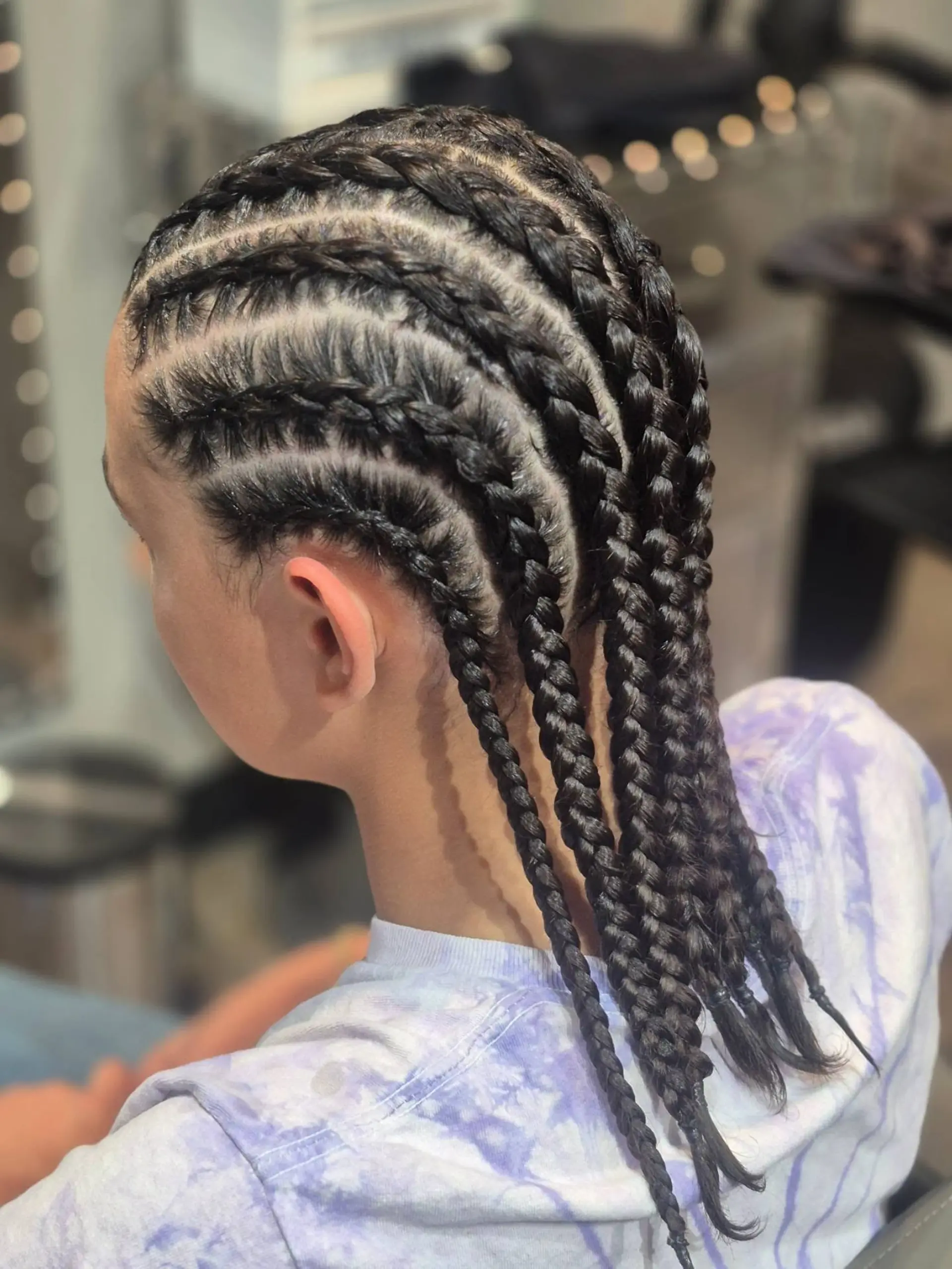 Neat, straight-back cornrow braids with clean parting extending down to the upper back. 1
