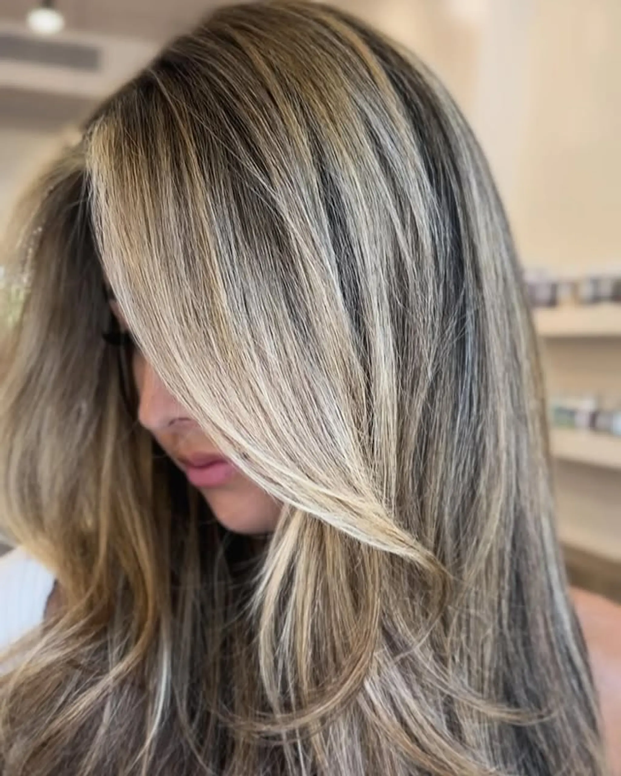 A beautiful bronde balayage with soft waves and face-framing layers.
