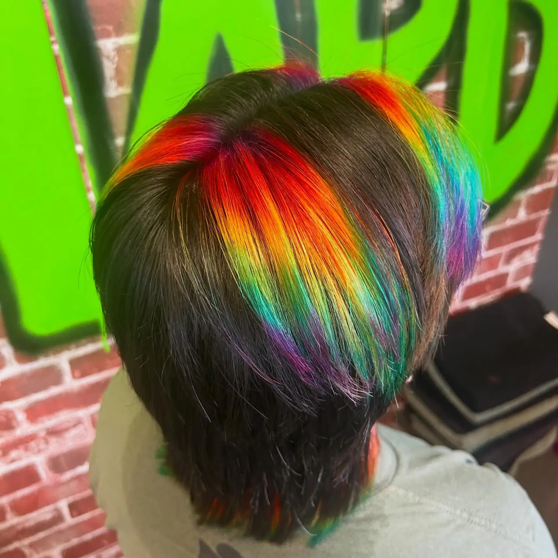Straight dark layered cut featuring bold, chunky rainbow prism vivid highlights across the crown. 1