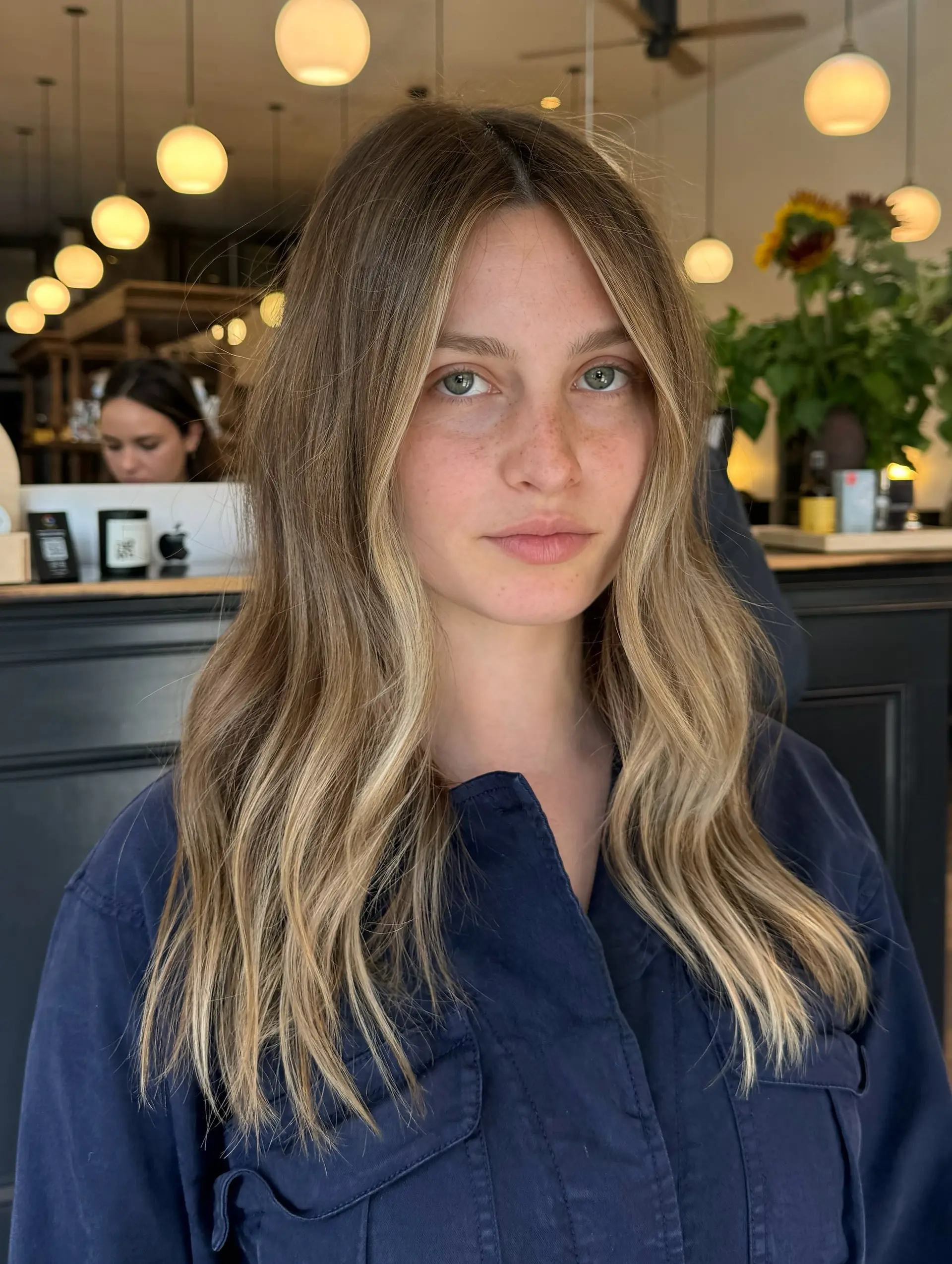 Center-parted long hair colored in a natural bronde blend with bright face-framing blonde highlights and styled in relaxed, soft waves. 1
