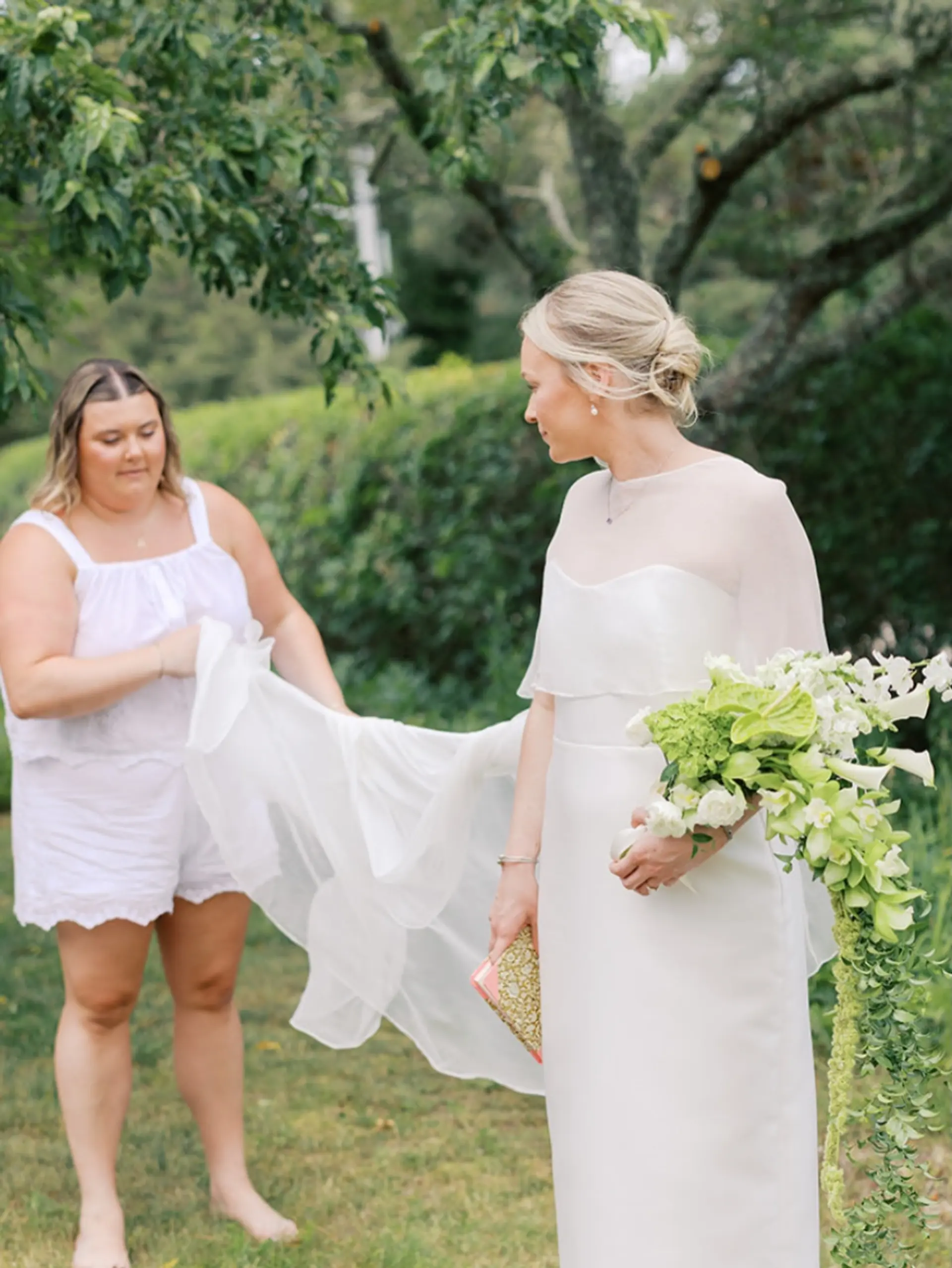 A sophisticated bridal low bun updo swept back neatly with subtle texture. 1