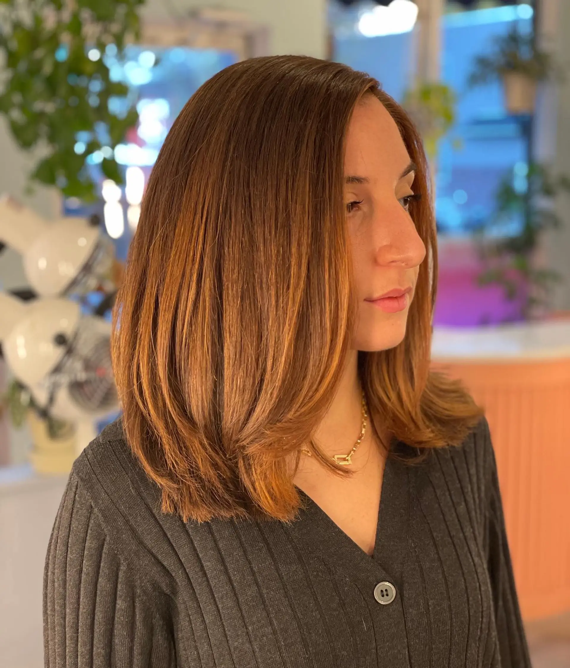 A trendy medium-length layered lob with copper highlights. 1
