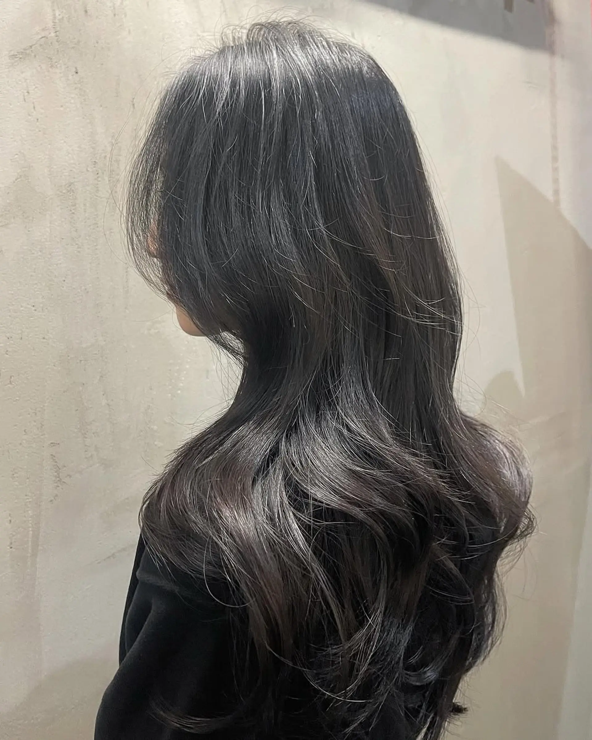 Long hair with soft, seamless layers that create a natural, voluminous wavy silhouette. The style incorporates face-framing sections to soften the features and create movement. 1