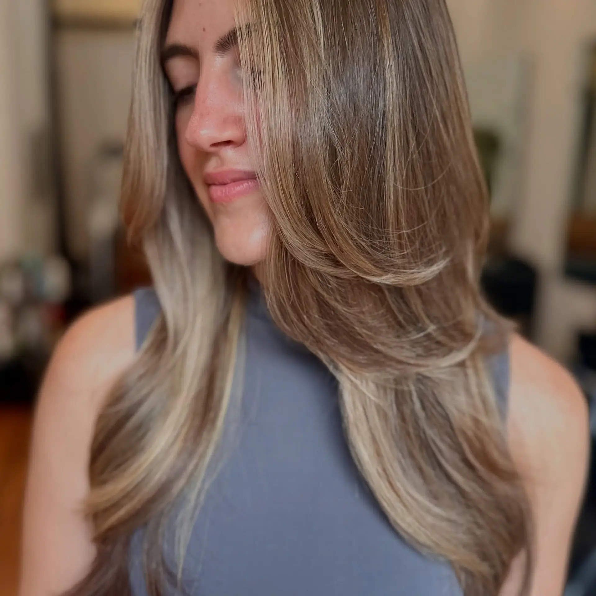 Long dimensional blonde hair styled with smooth face-framing layers and a voluminous blowout finish. 1