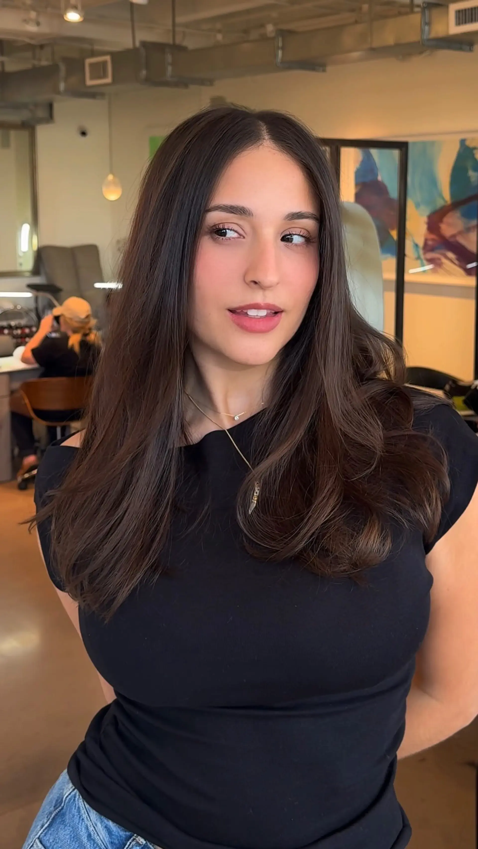 A rich, glossy dark brown haircut with a clean center part and voluminous blowout featuring soft, inward-curving ends. 1