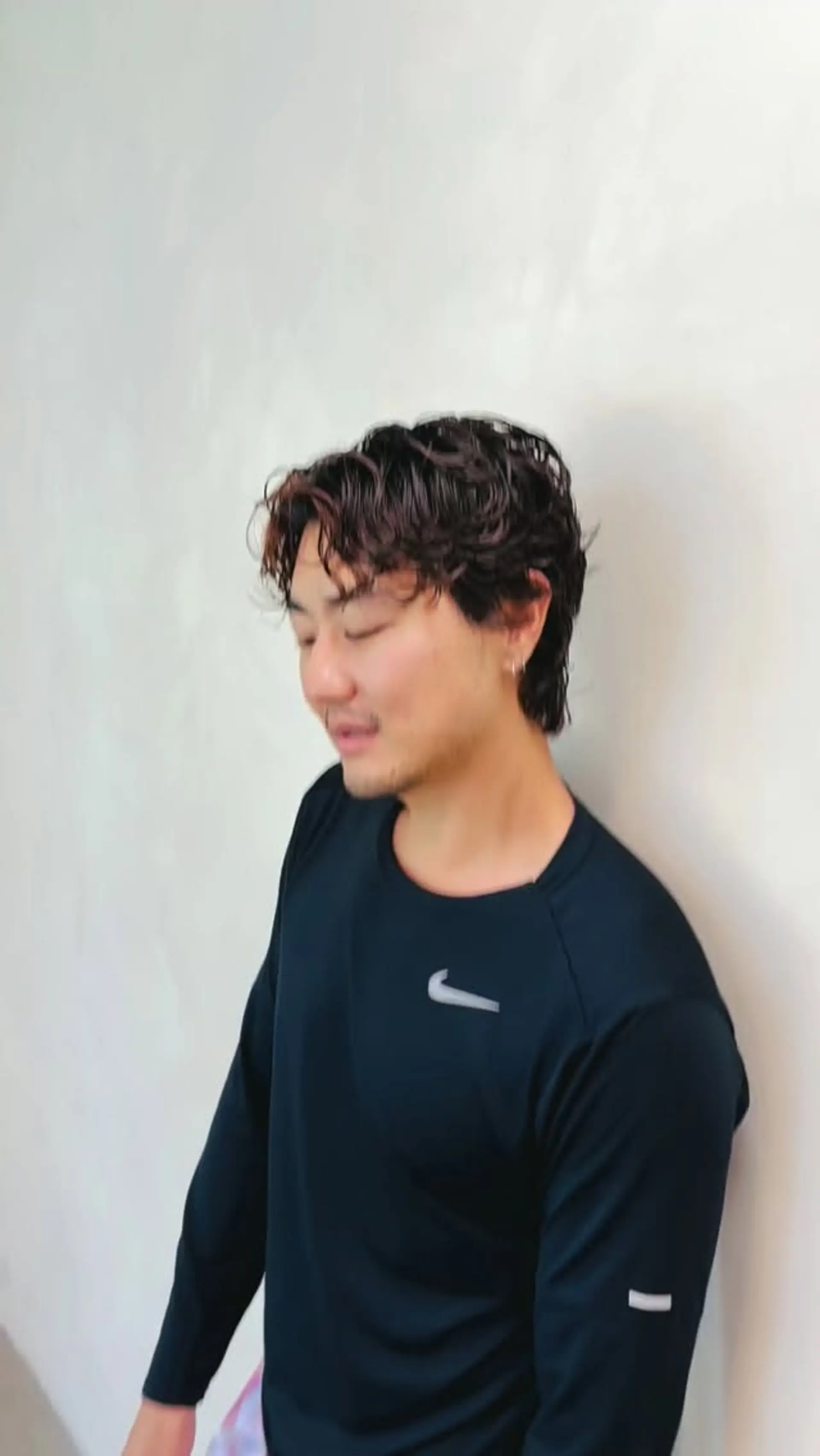 A textured men's perm featuring soft, defined waves and natural volume on top with gently tapered sides. 1