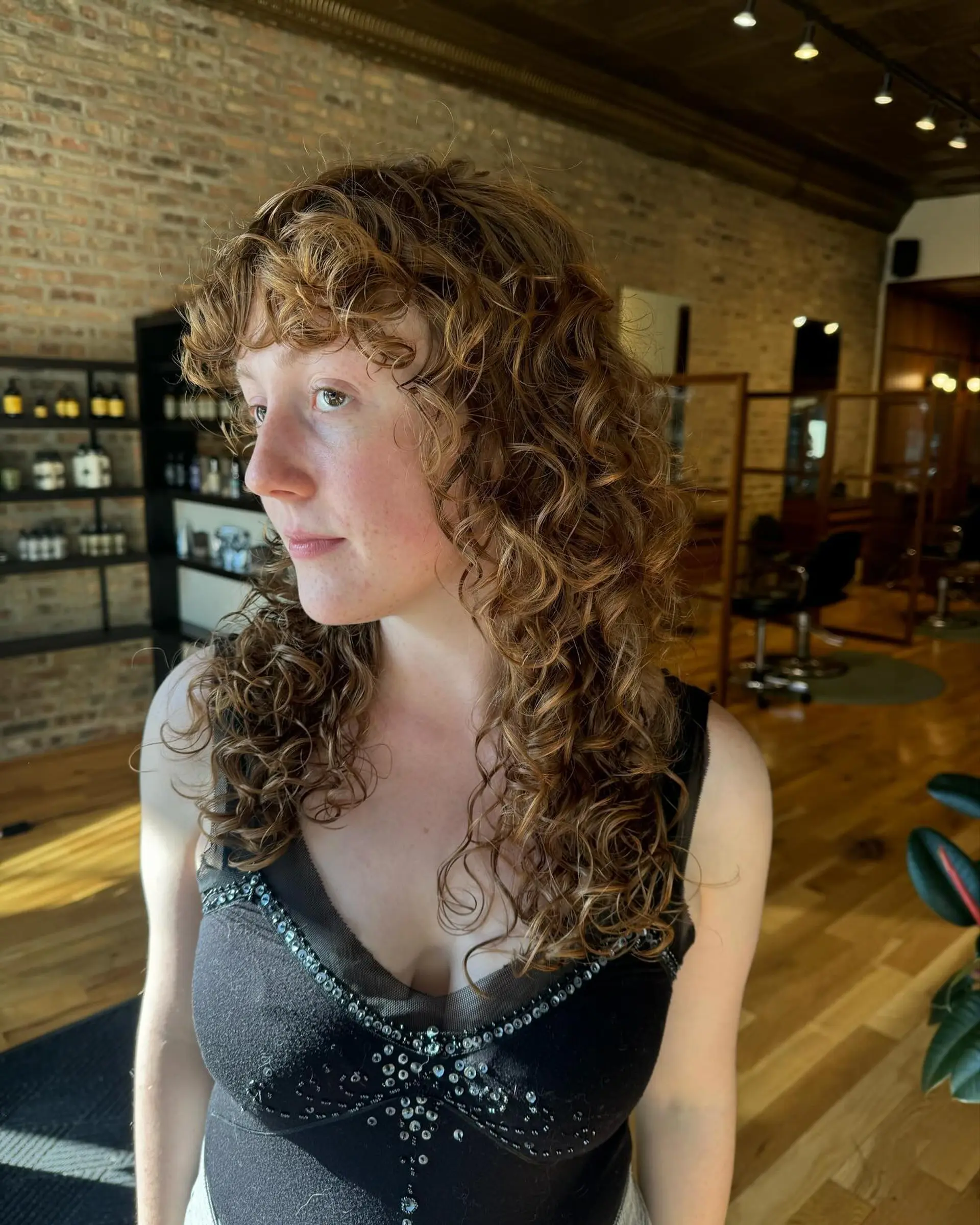 A modern shag haircut with lots of curly layers and face-framing bangs. 1