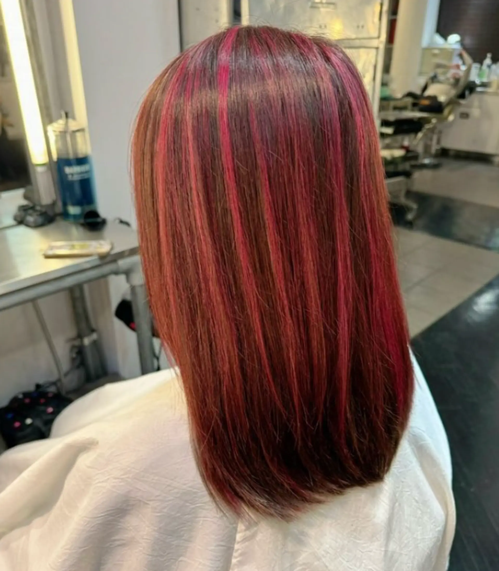 Sleek, straight medium length hair with a rich brown base and vibrant red highlights, featuring an ombre effect.

 1