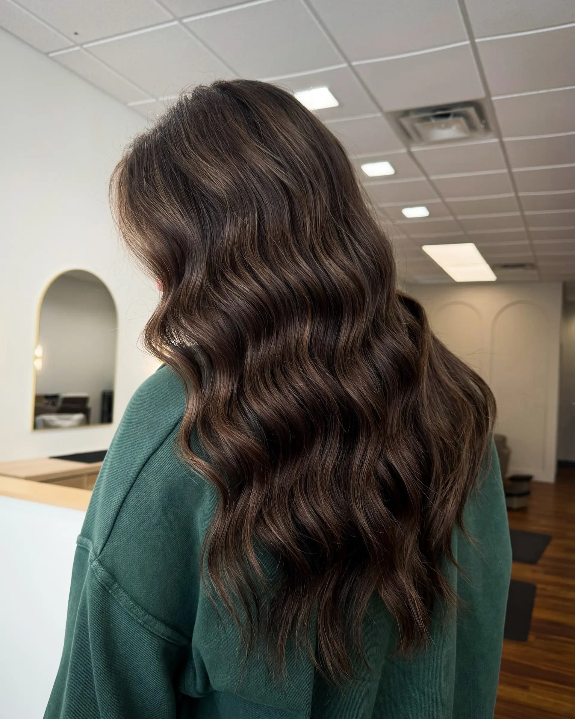 Long, glossy espresso brunette hair styled with smooth, cascading thermal waves. 1