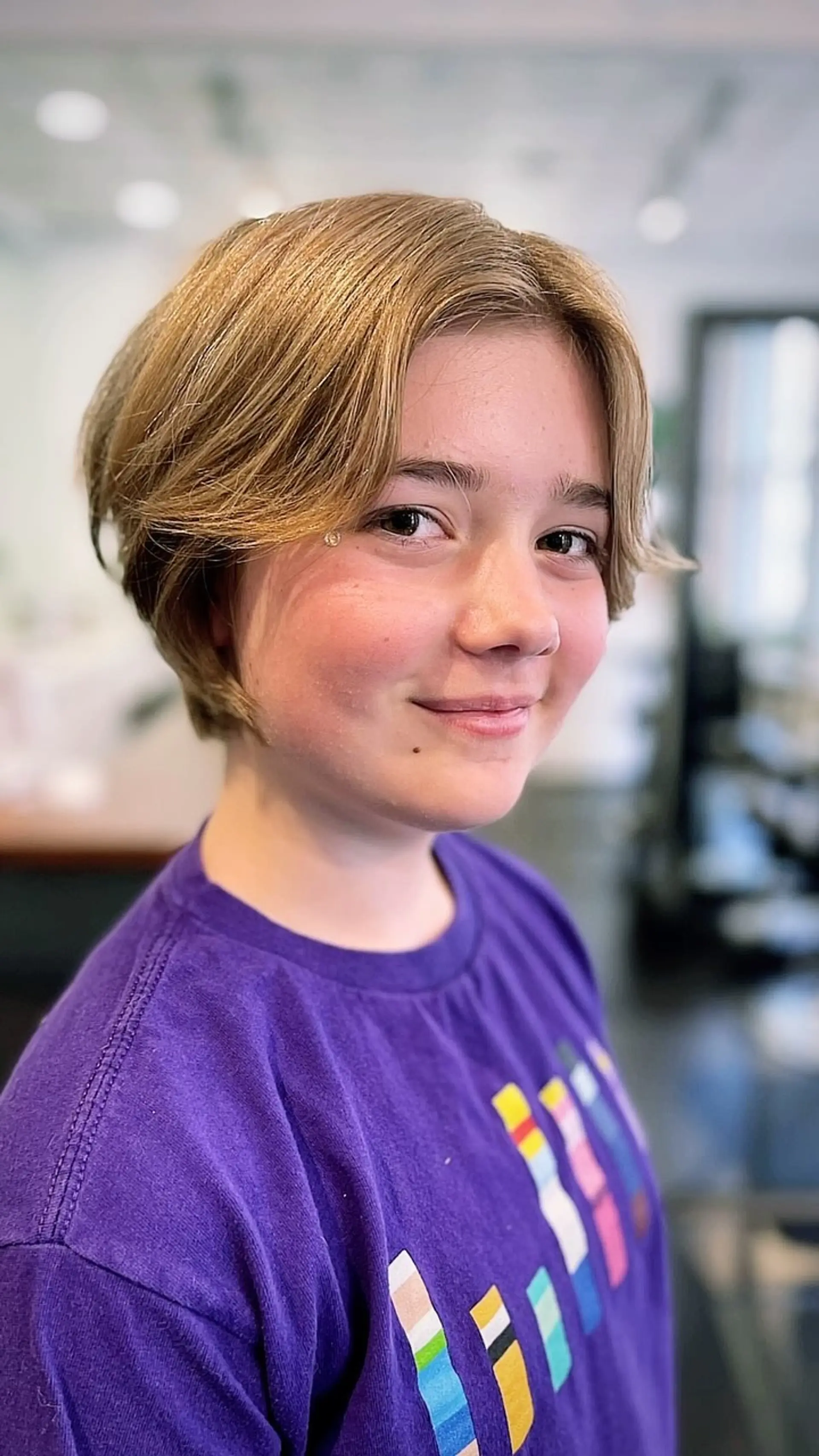 A textured short bob haircut featuring center-parted curtain bangs framing the face. 1