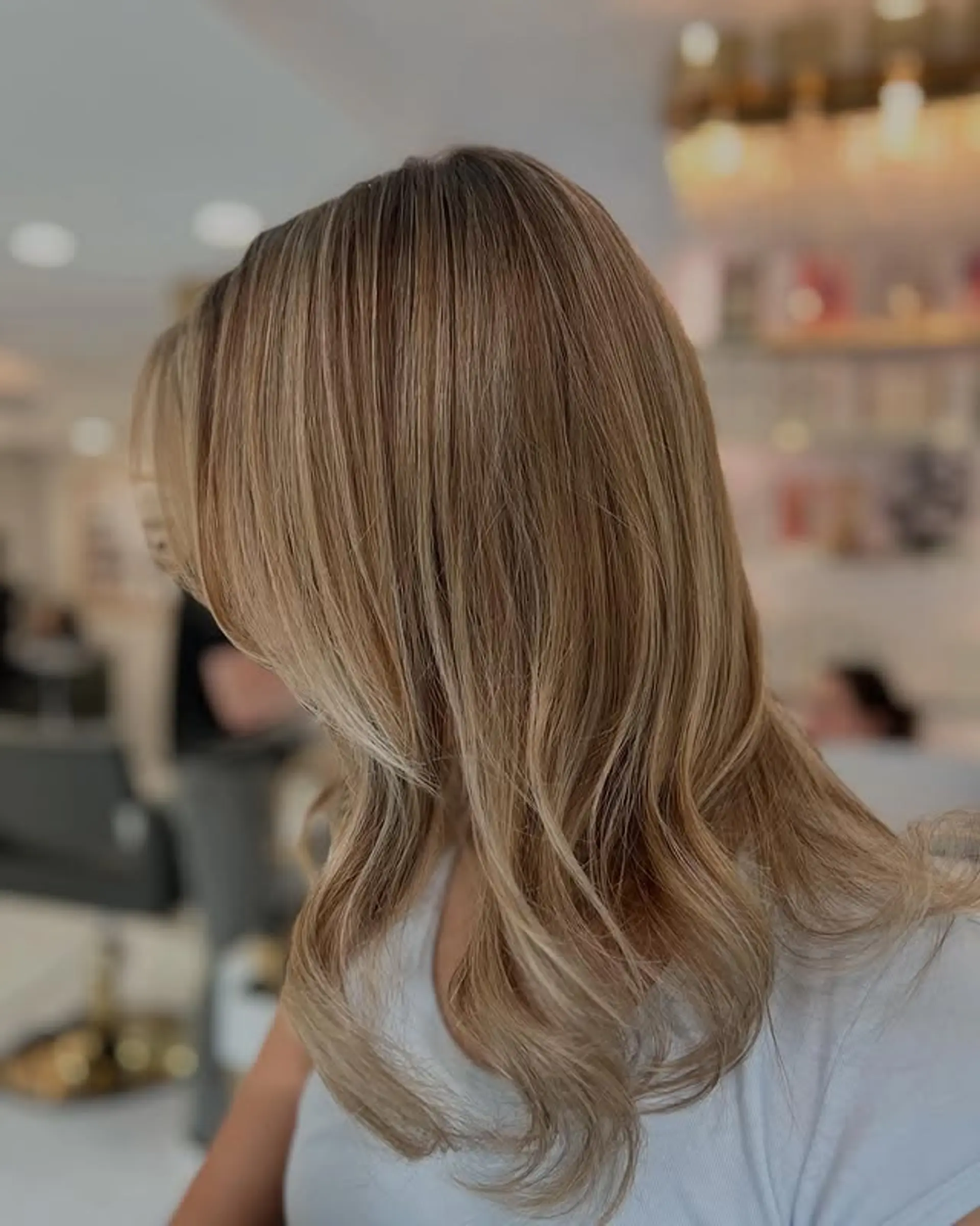 A medium length, layered cut with soft waves, perfect for enhancing natural movement and volume. 1