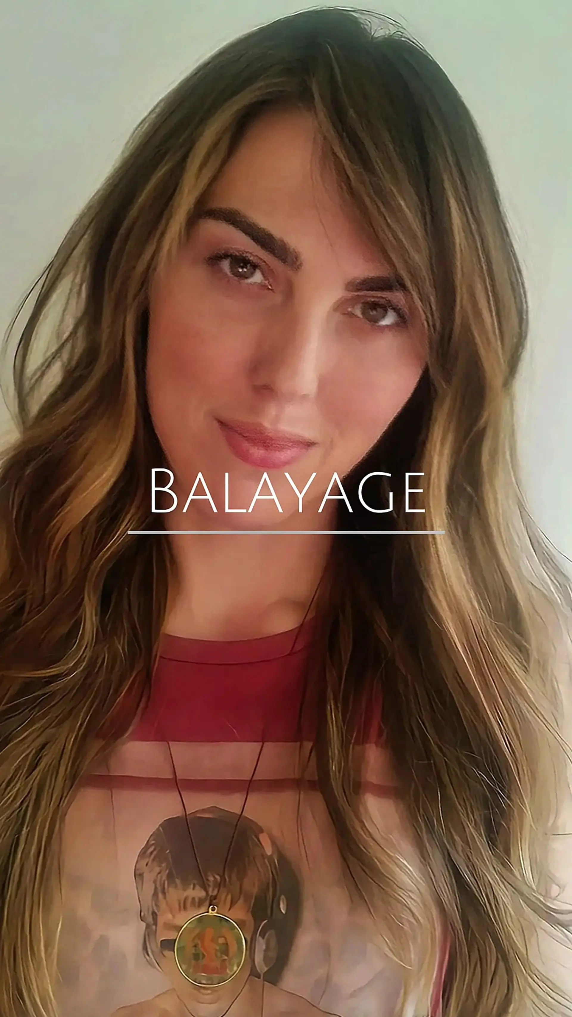 Long, tousled brunette hair styled with subtle natural waves and warm honey-toned balayage highlights. 1