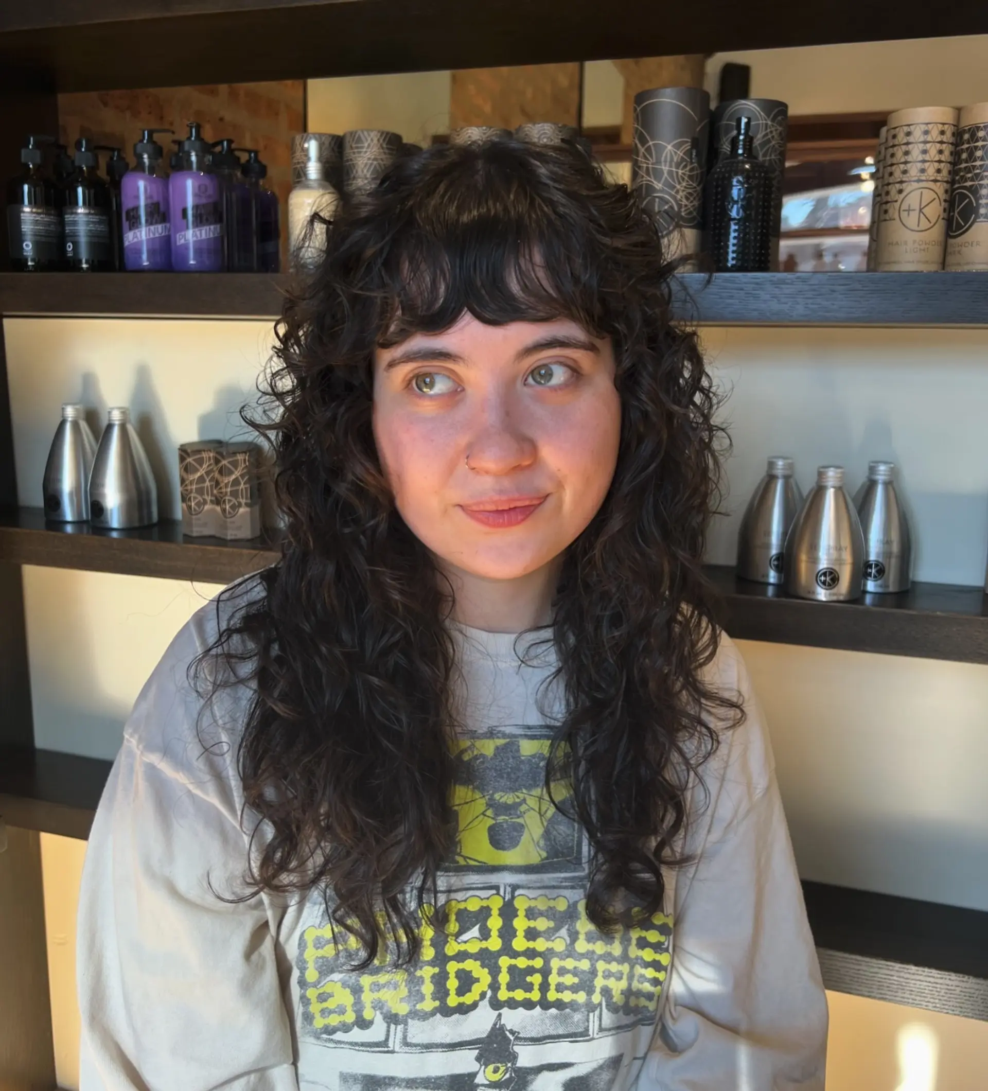 This hairstyle is a long, curly shag with layered texture and face-framing bangs. 1