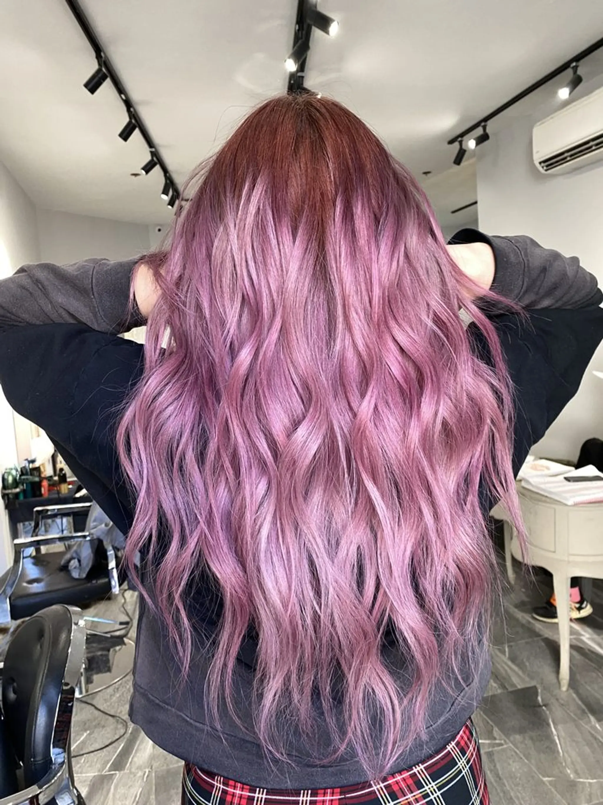 Long, wavy locks dyed in a captivating blend of purple and lavender, flowing down in loose, relaxed waves, creating a dreamy and ethereal appearance.