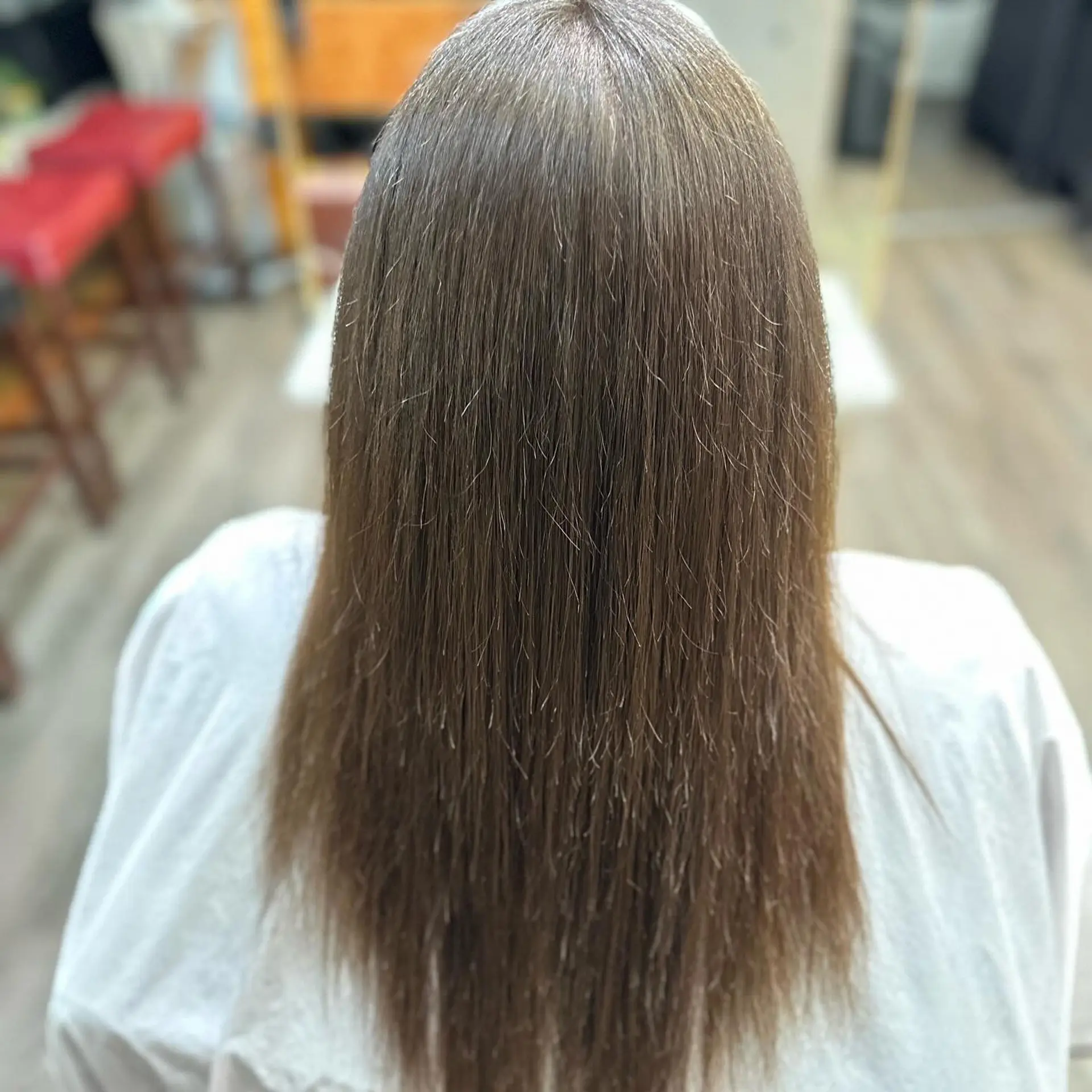 Long, sleek straight brunette hair styled with a smooth, glossy finish following a straightening treatment. 1