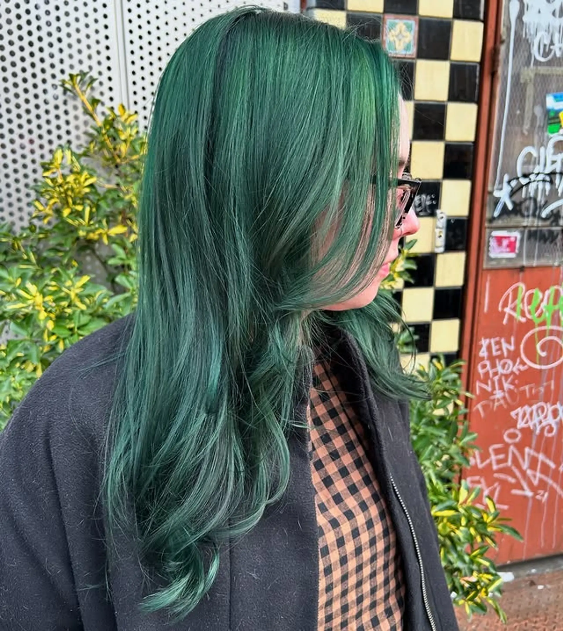 Long, layered straight hair dyed a vibrant emerald green. 1