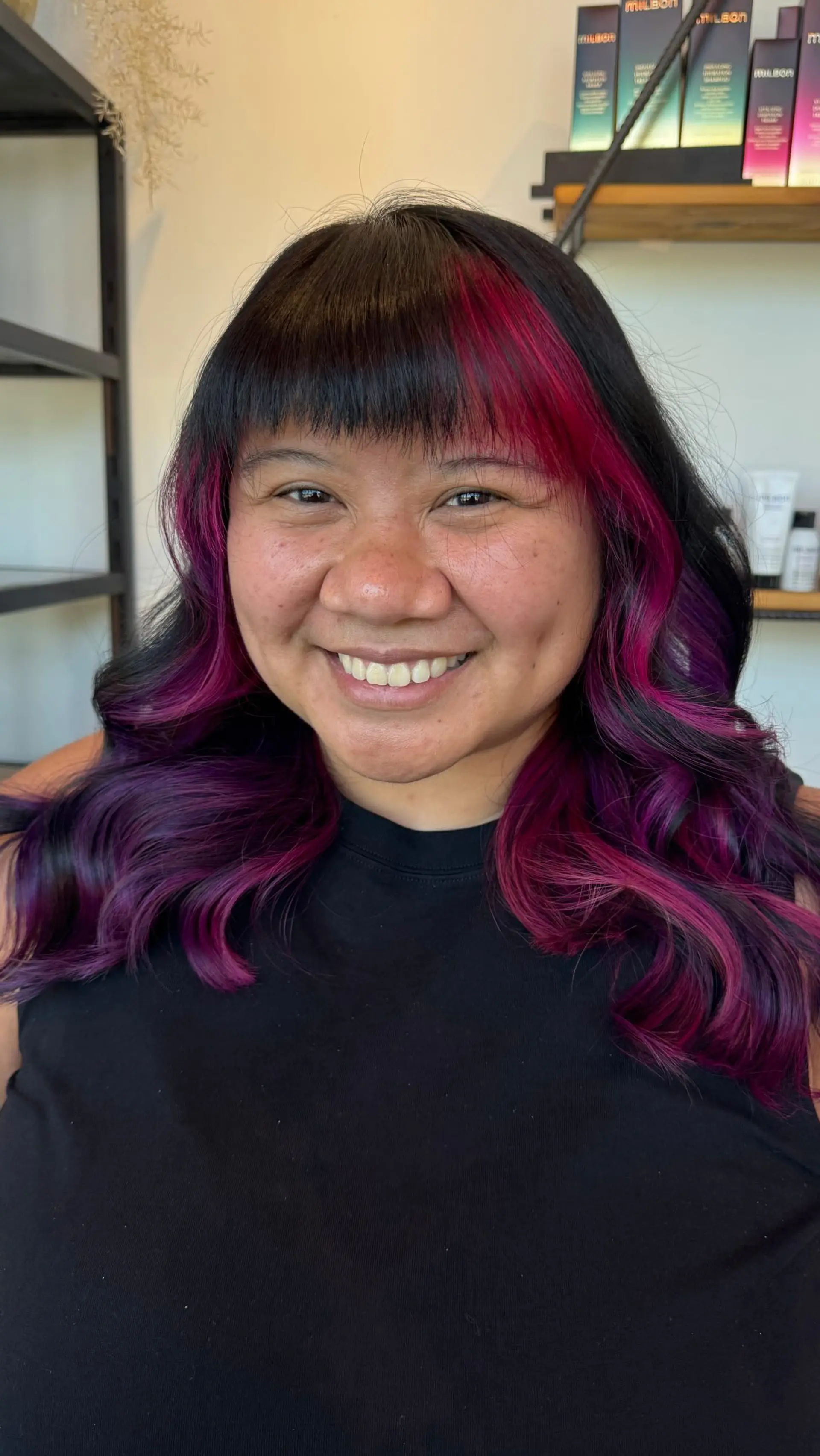 Medium-length wavy black hair featuring vibrant magenta and purple face-framing peekaboo highlights and straight blunt bangs. 1