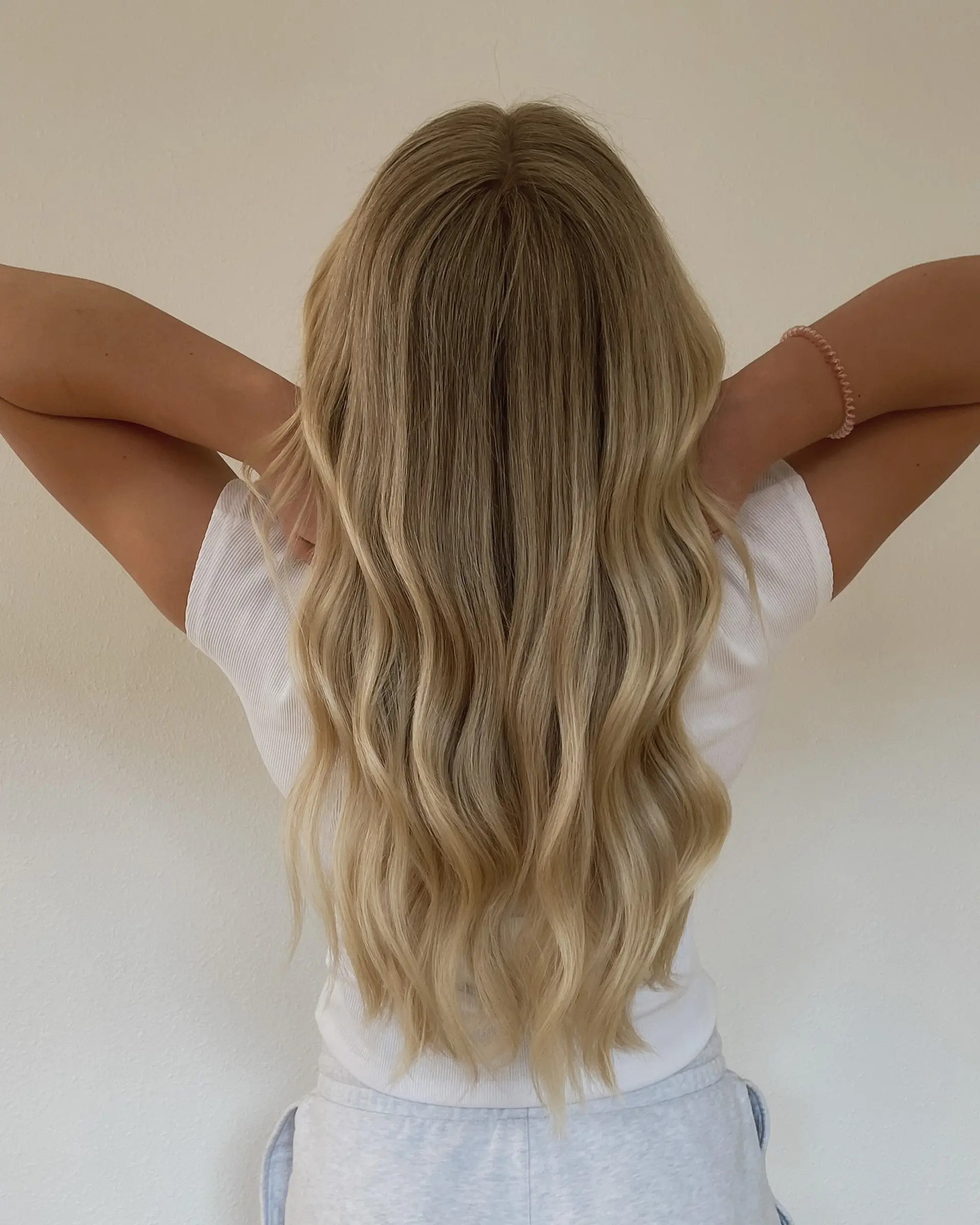 Long golden blonde hair with blended balayage highlights styled in loose waves. 1