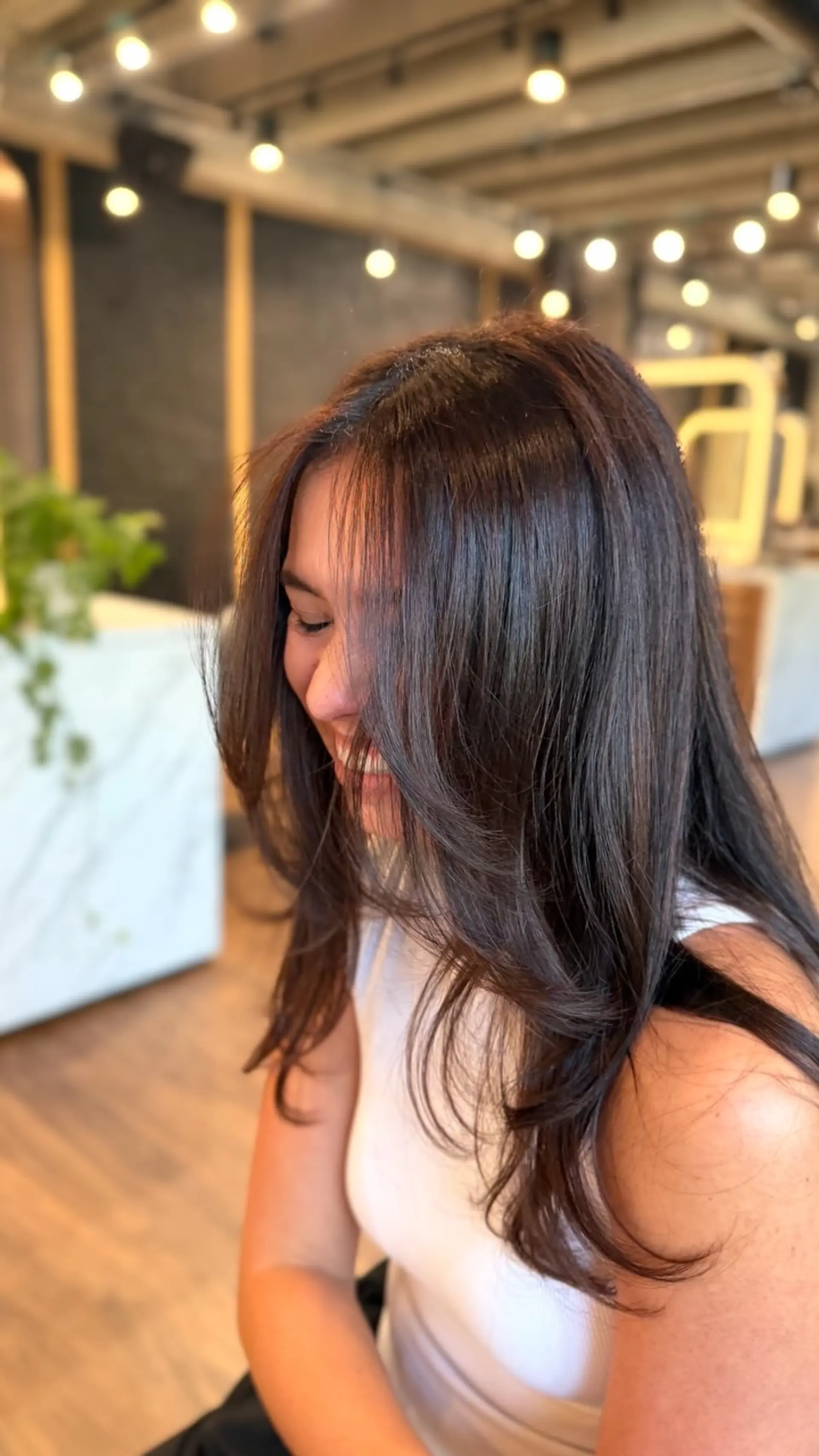 Long dark brunette hair featuring subtle warm dimensional balayage, cut with soft face-framing layers and styled with a smooth blowout. 1