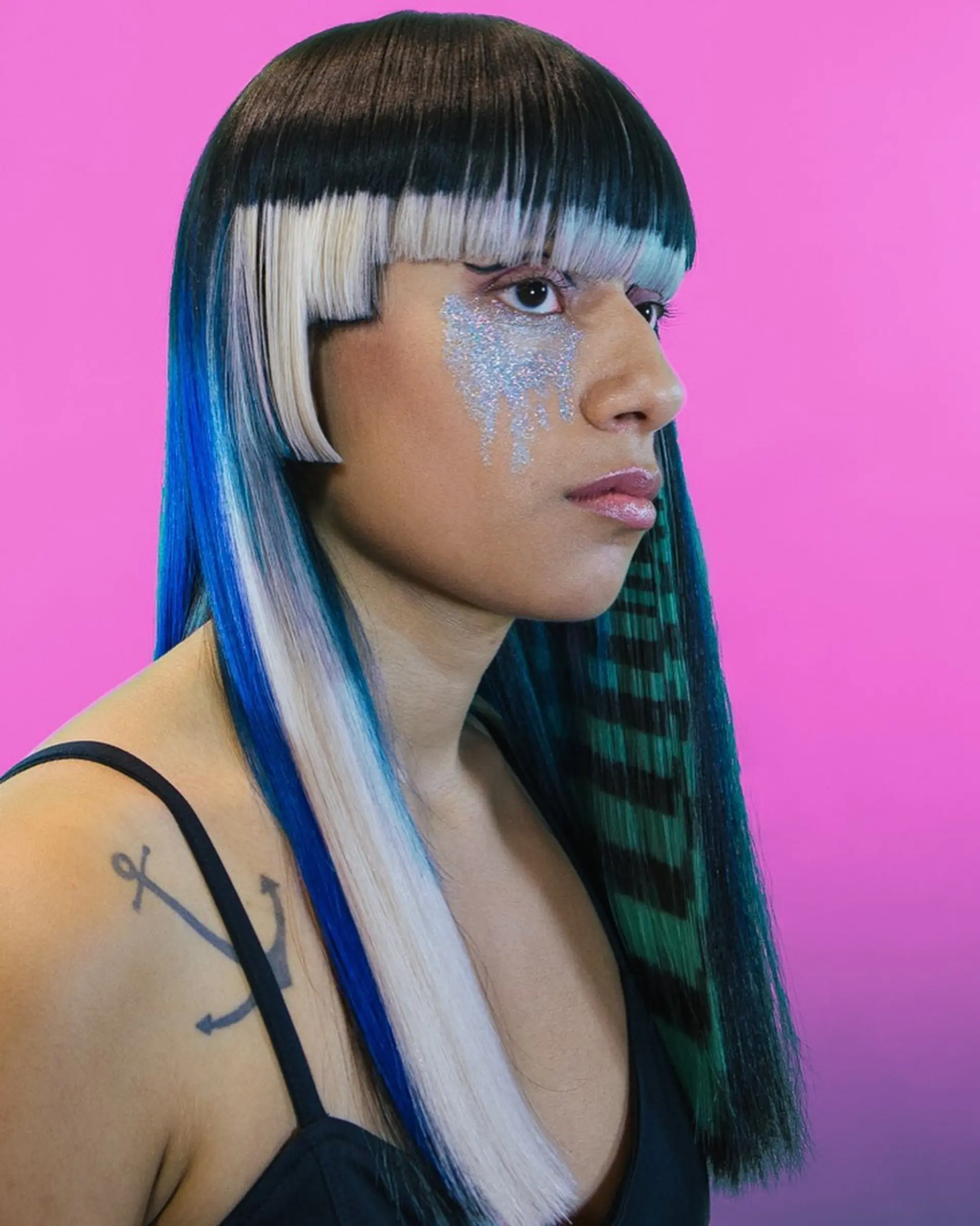 A sleek, futuristic straight hairstyle featuring blunt geometric bangs and side steps in platinum blonde against dark hair, paired with blue accents and green striped extensions. 1