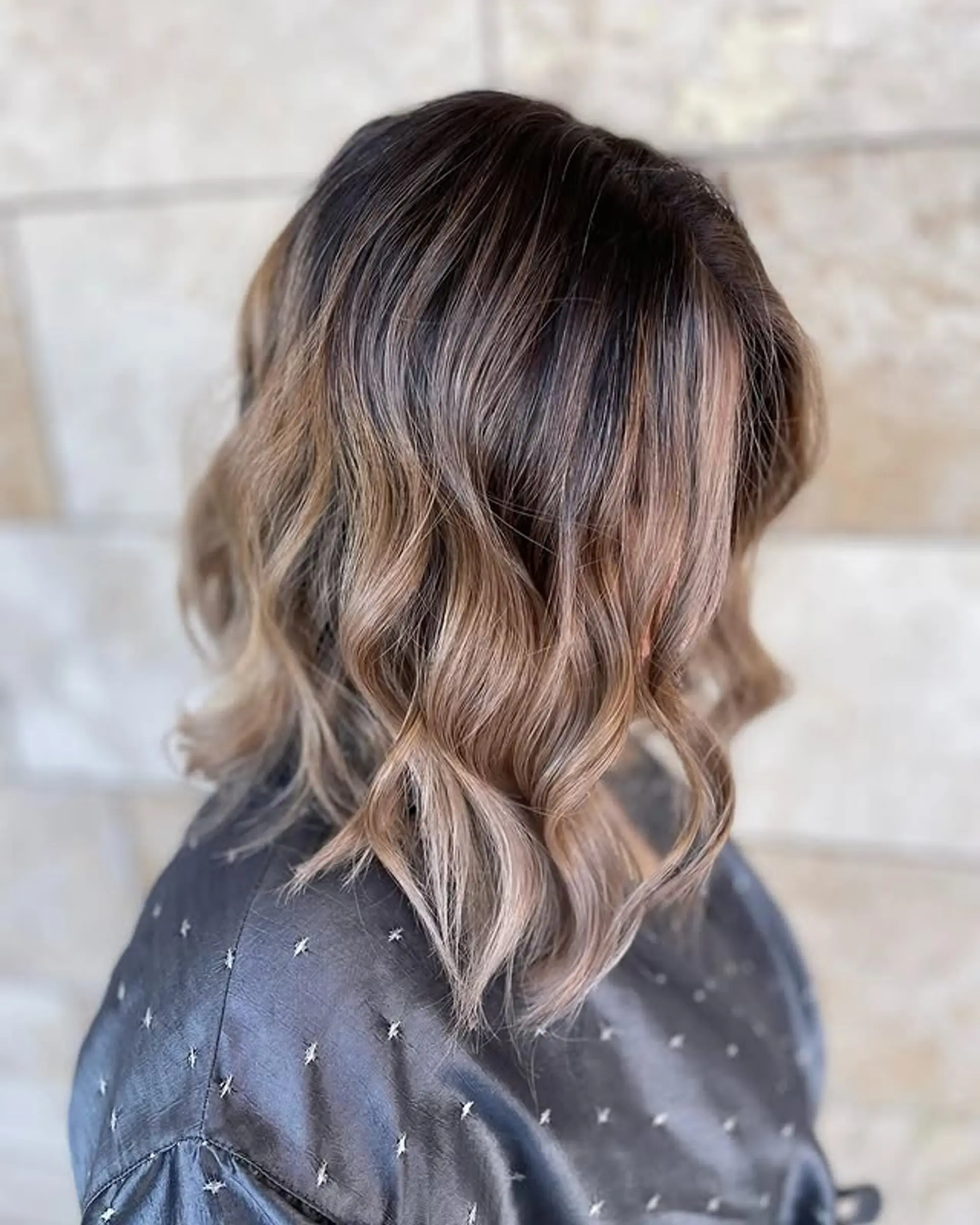 A shoulder-length bob with loose beach waves in a bronde color. 1