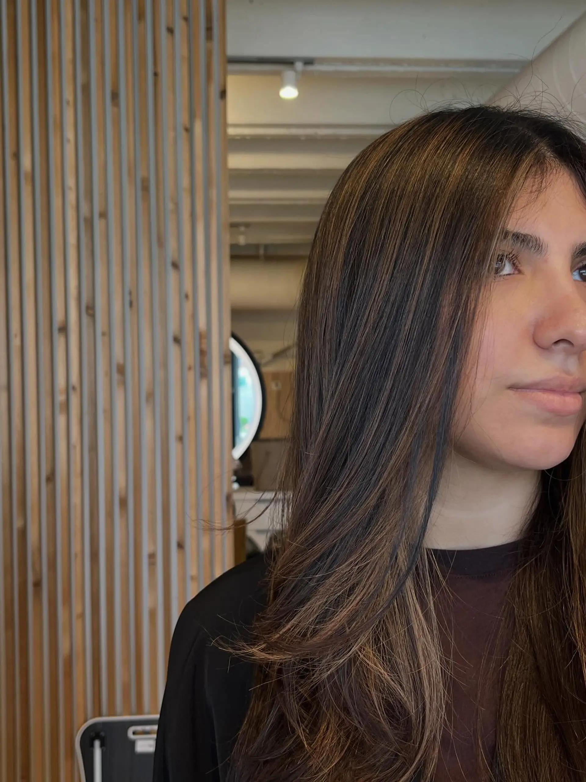 Long dark brown hair enhanced with seamless caramel balayage highlights and soft face-framing layers. 1