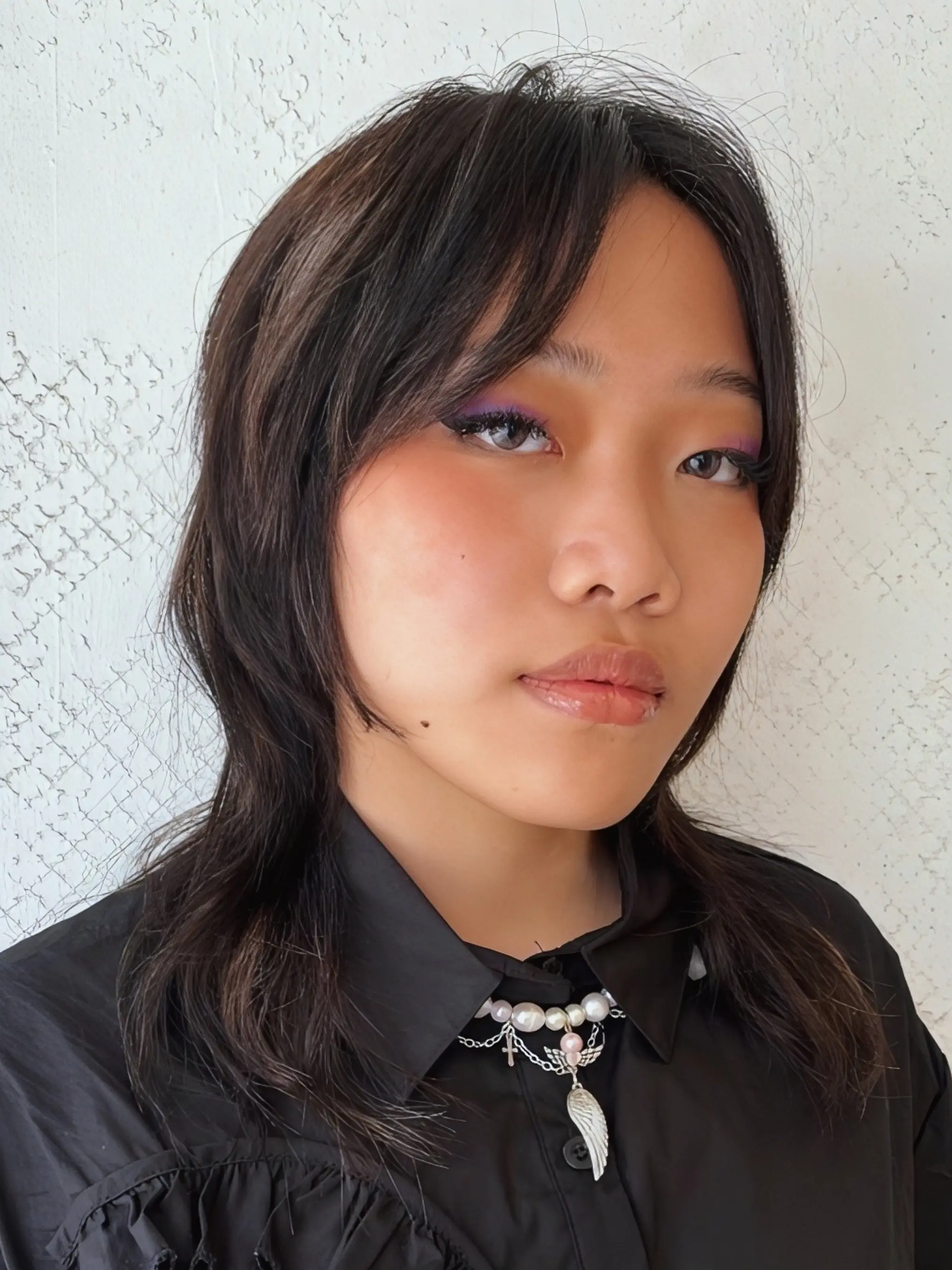 Layered, face-framing medium-length cut with feathered textures in a sleek, straight style.