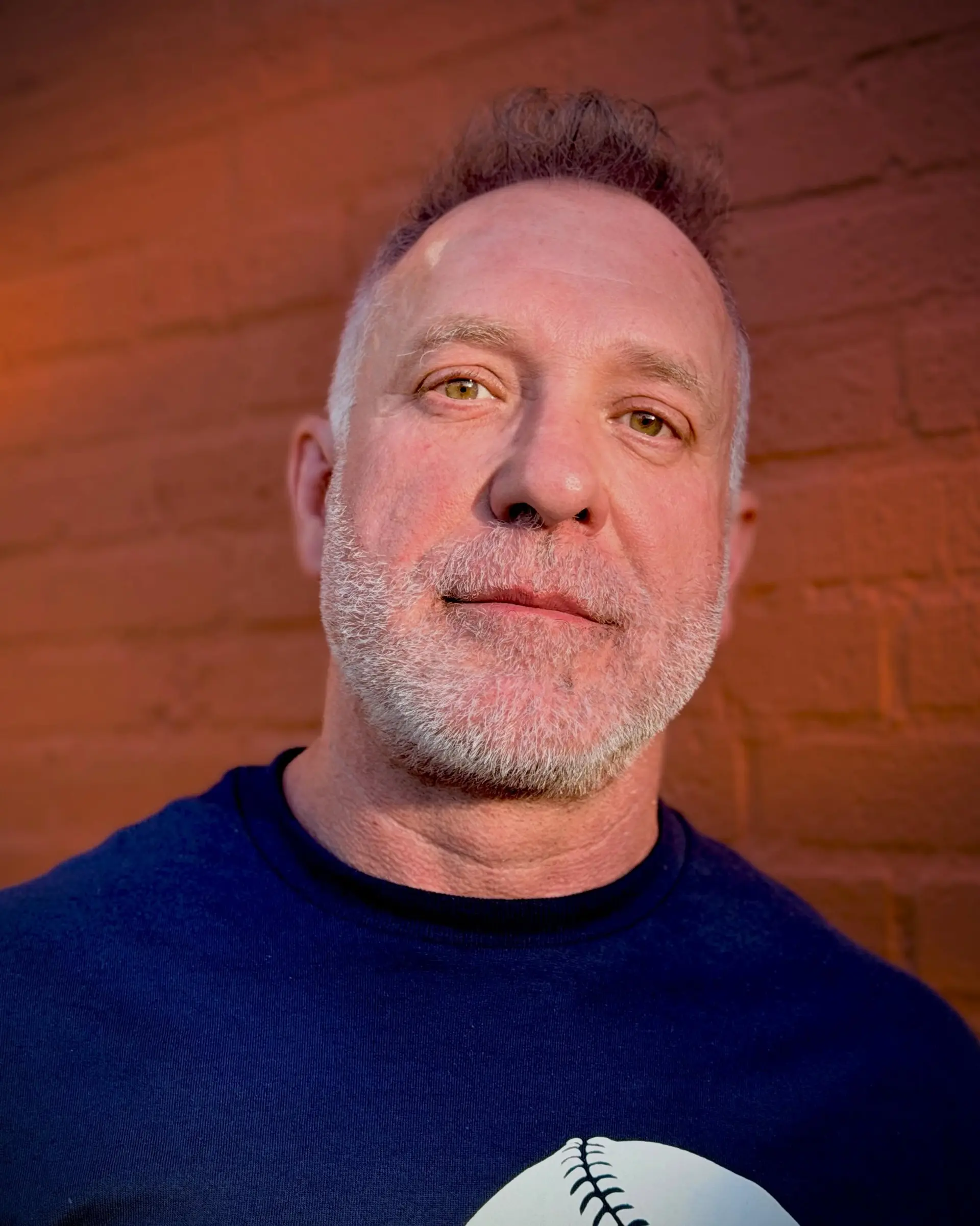 A men's short haircut featuring a textured, lifted top paired with a closely groomed salt-and-pepper beard. 1