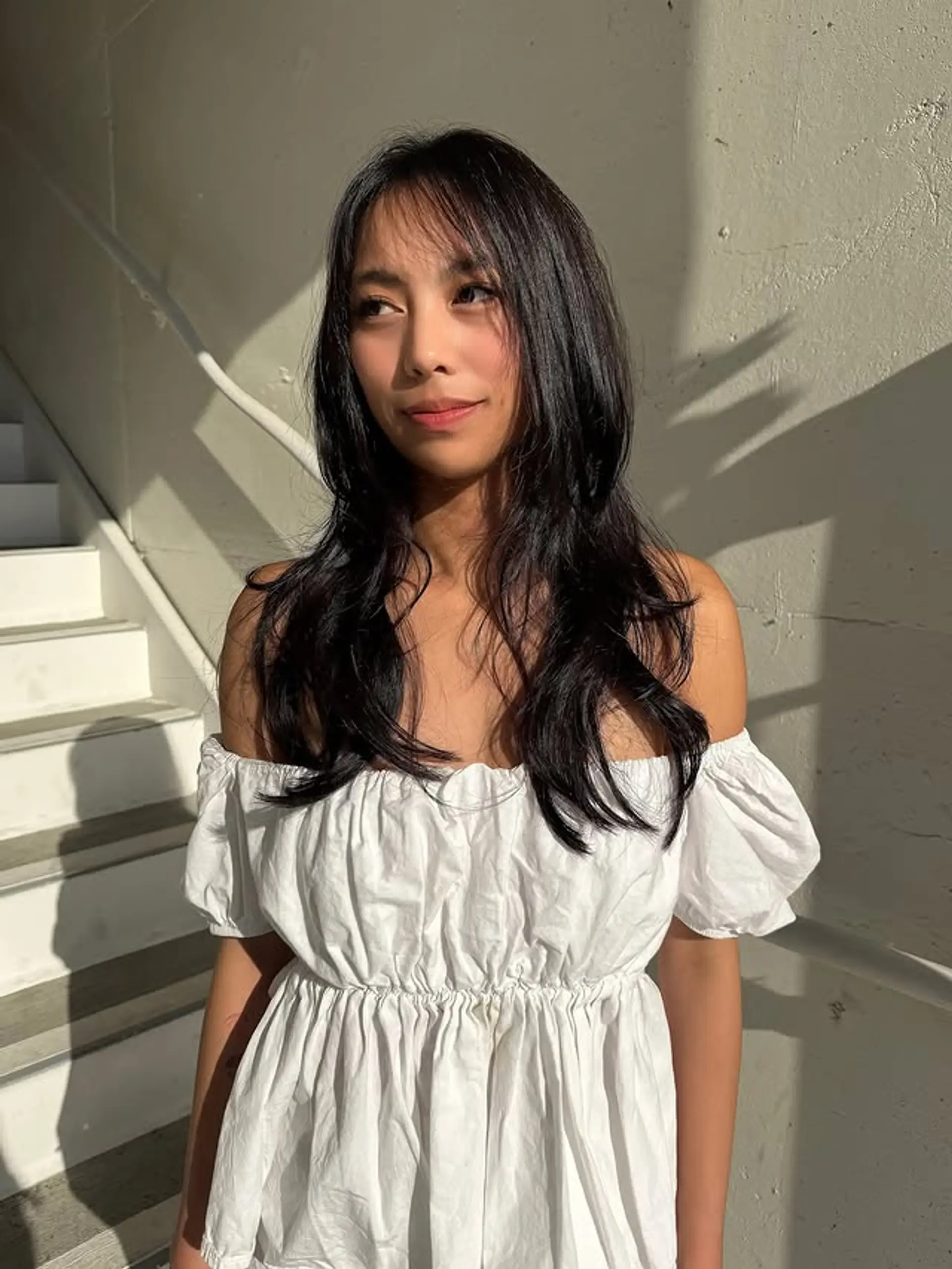 This hairstyle features long, black hair with soft layers and face-framing bangs. 1