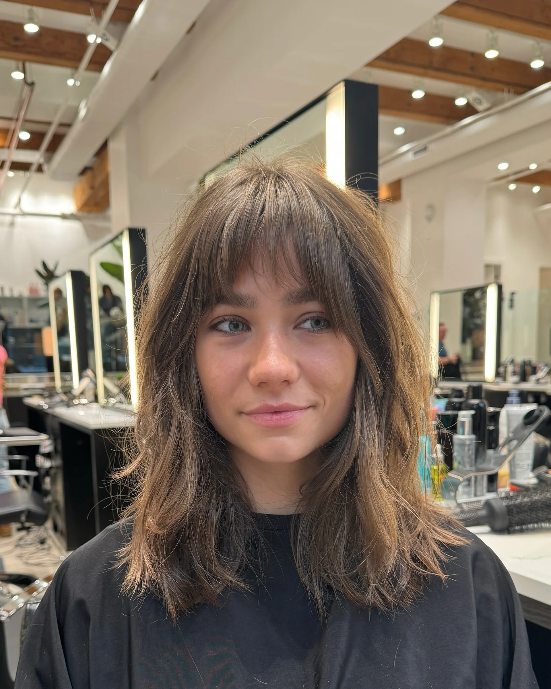 Modern textured shag haircut with curtain bangs showing effortless rock-n-roll movement - Preview 1