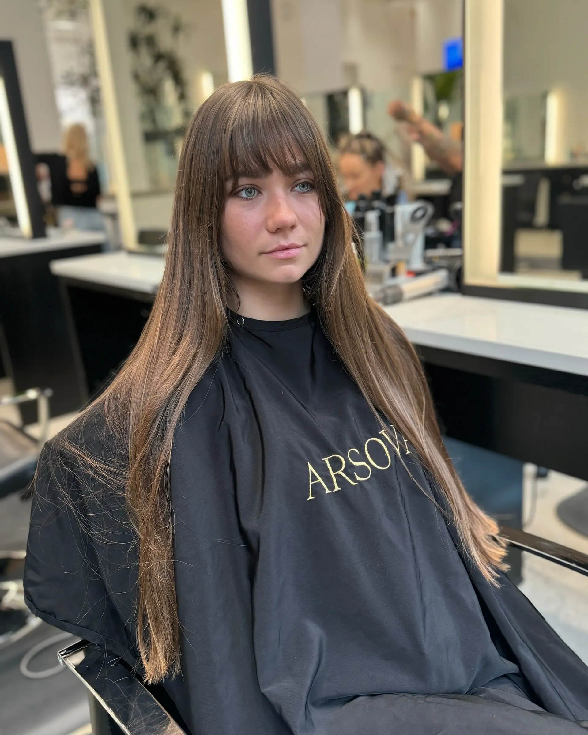 A medium-length shag haircut with face-framing layers and curtain bangs. 2