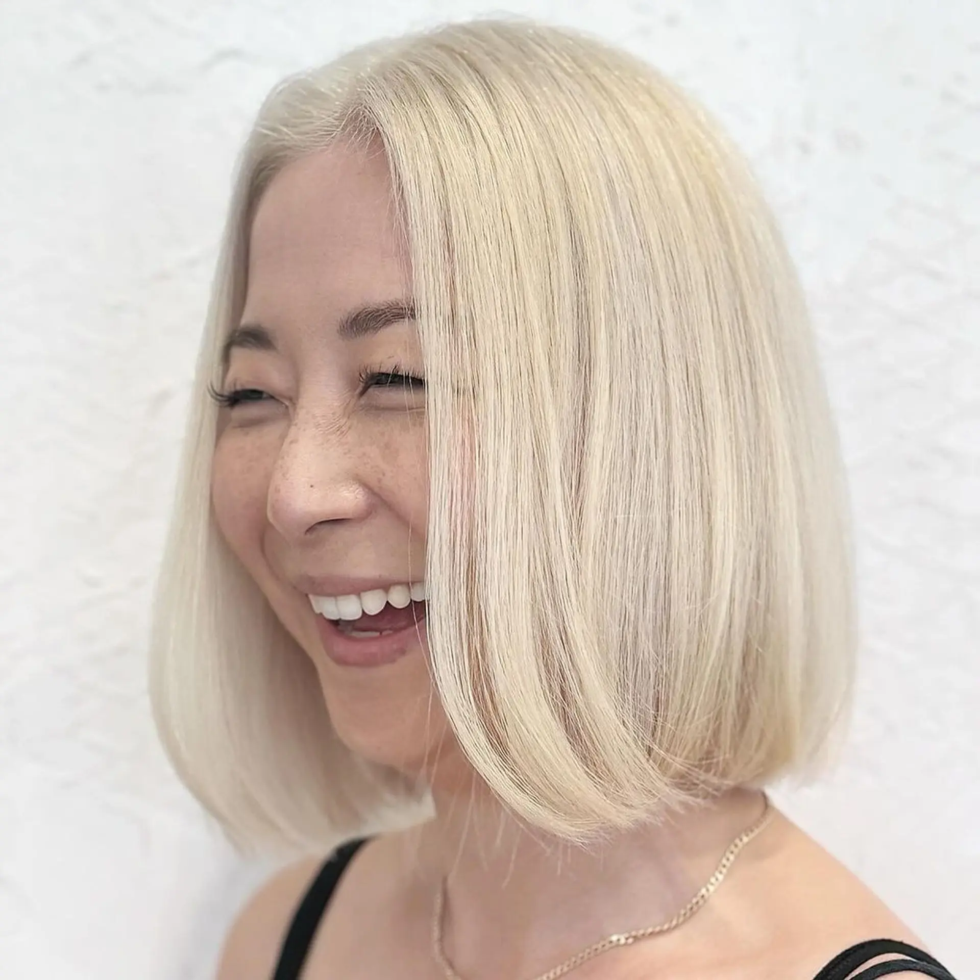 A sleek, medium-length bob with a blunt cut, straight and dyed a striking platinum blonde. 2