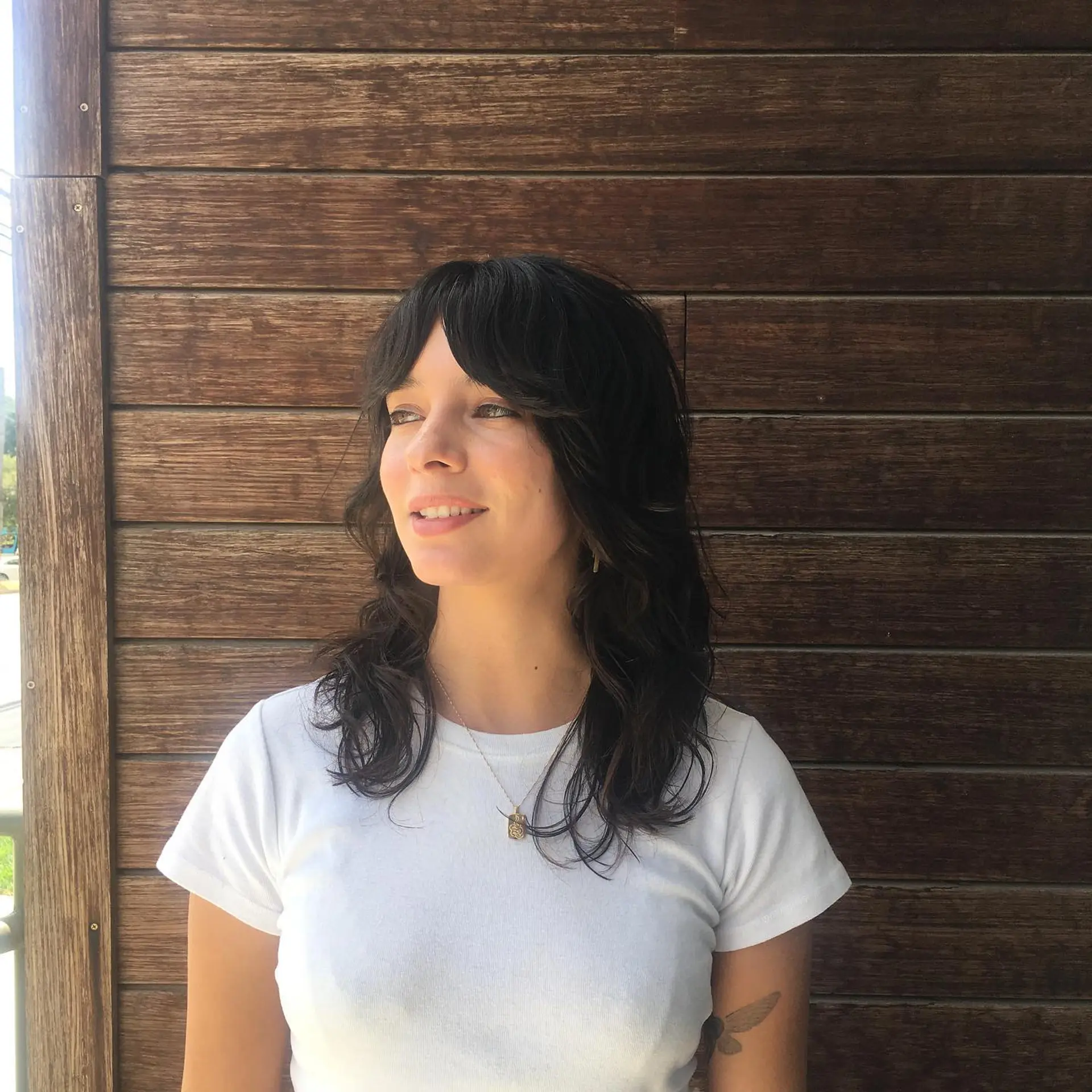 A dark brown shag haircut featuring textured layers and soft curtain bangs. 1