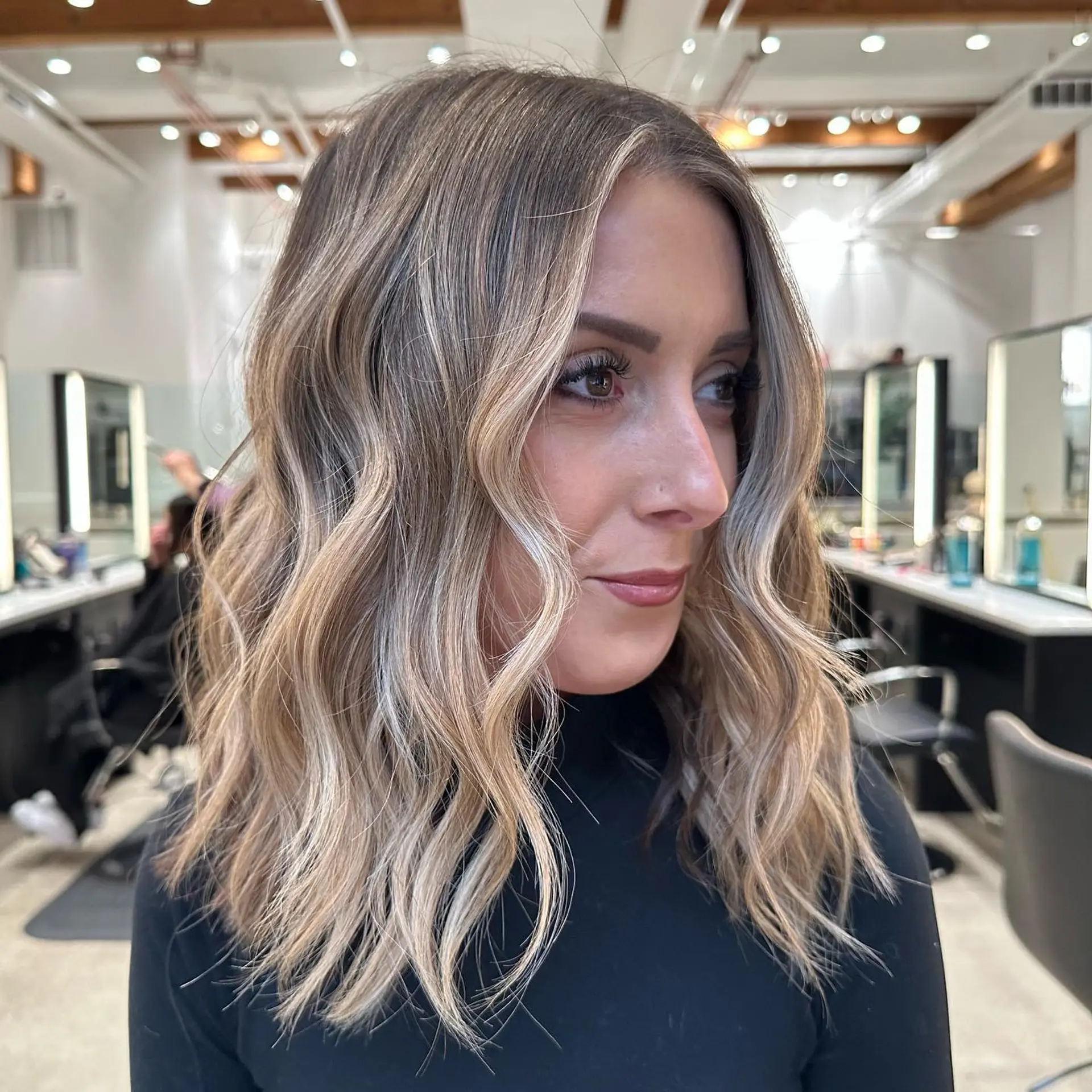 A medium-length hairstyle with beachy waves and balayage. 1