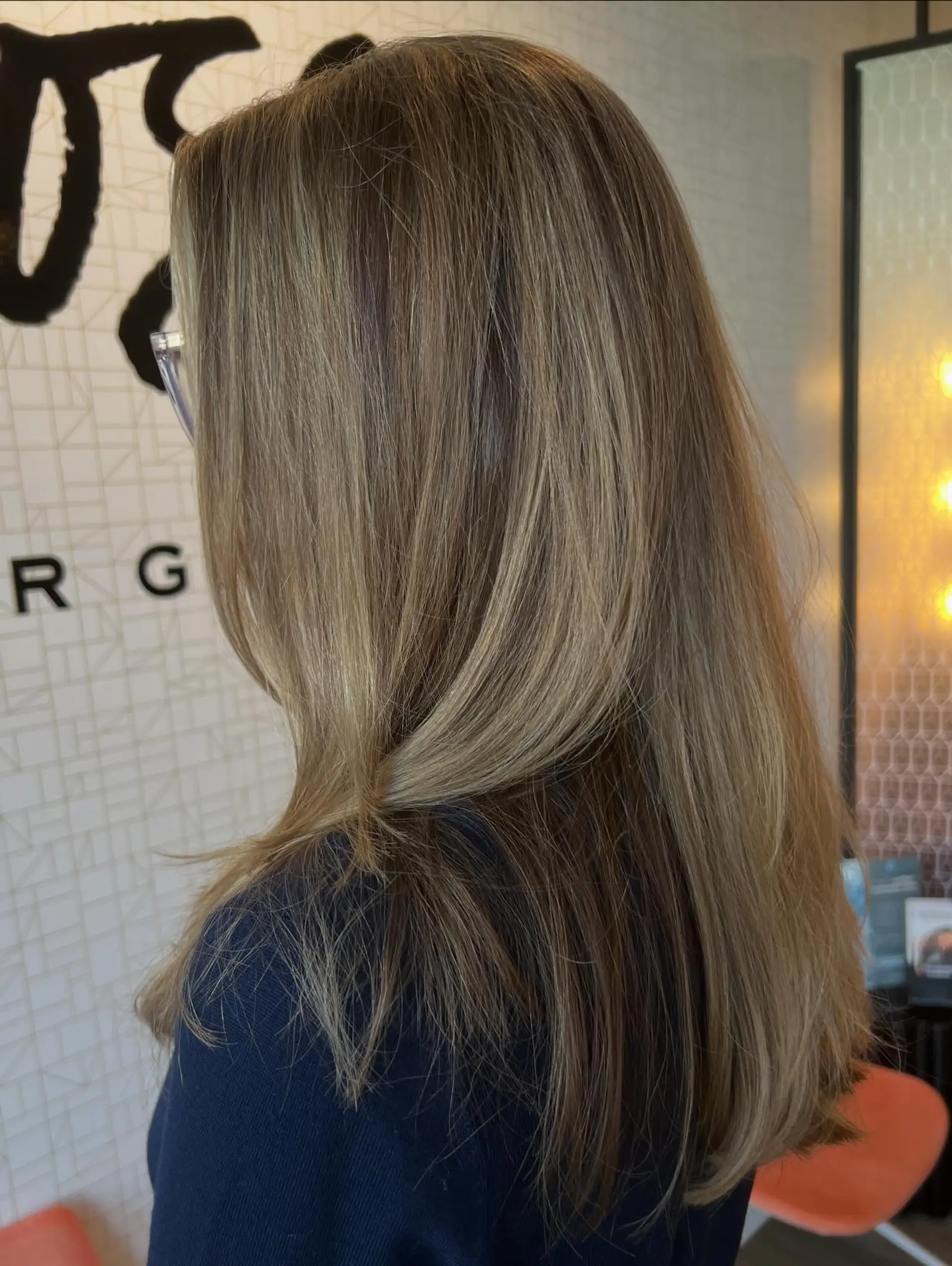 Long layered hair styled straight with subtle movement, featuring soft dimensional honey and warm blonde tones blended seamlessly over a light brown base. 1