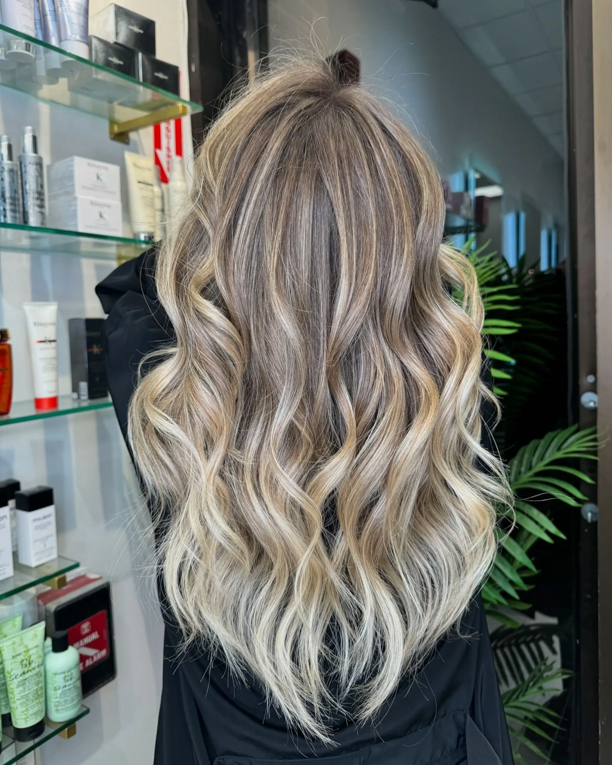 Voluminous, flowing waves in dark blonde, platinum blonde, and golden blonde hues, styled in loose, beachy waves with meticulous highlights.