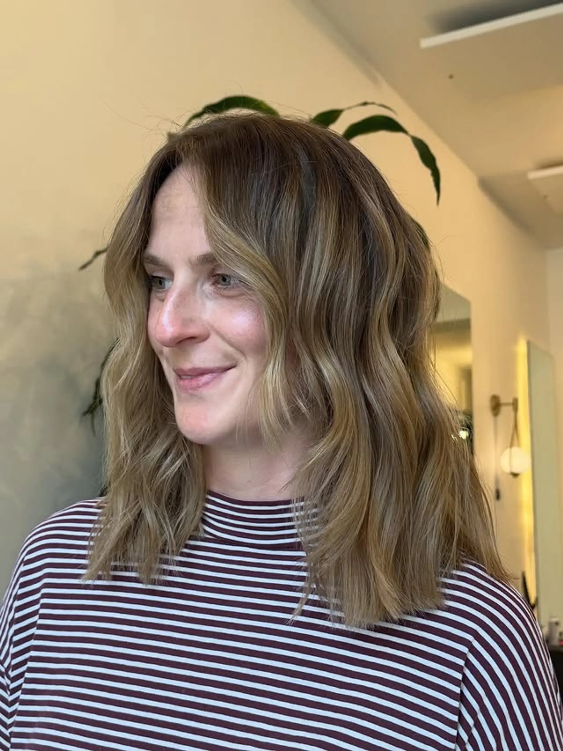 A trendy bronde balayage lob (long bob) with soft, face-framing layers that add dimension and movement to wavy hair. 1