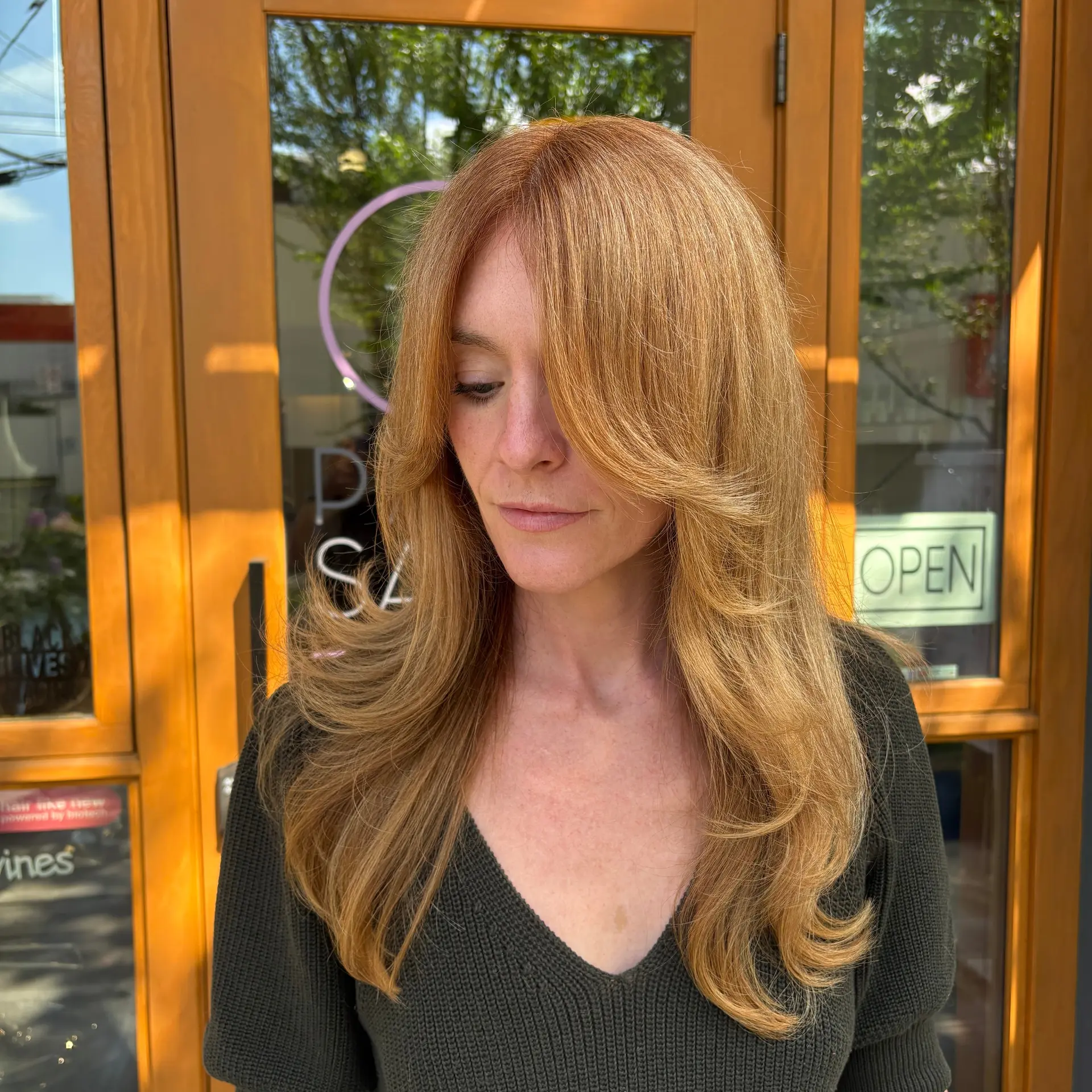 Long strawberry blonde hair featuring a butterfly layered cut with soft curtain bangs. 1