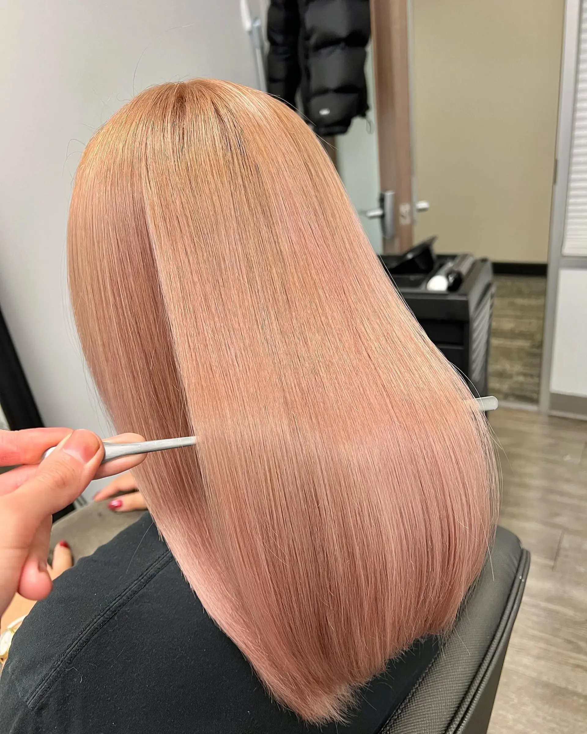 Ultra-glossy, pin-straight medium-length hair in a soft rose gold hue, styled sleek and smooth. 1