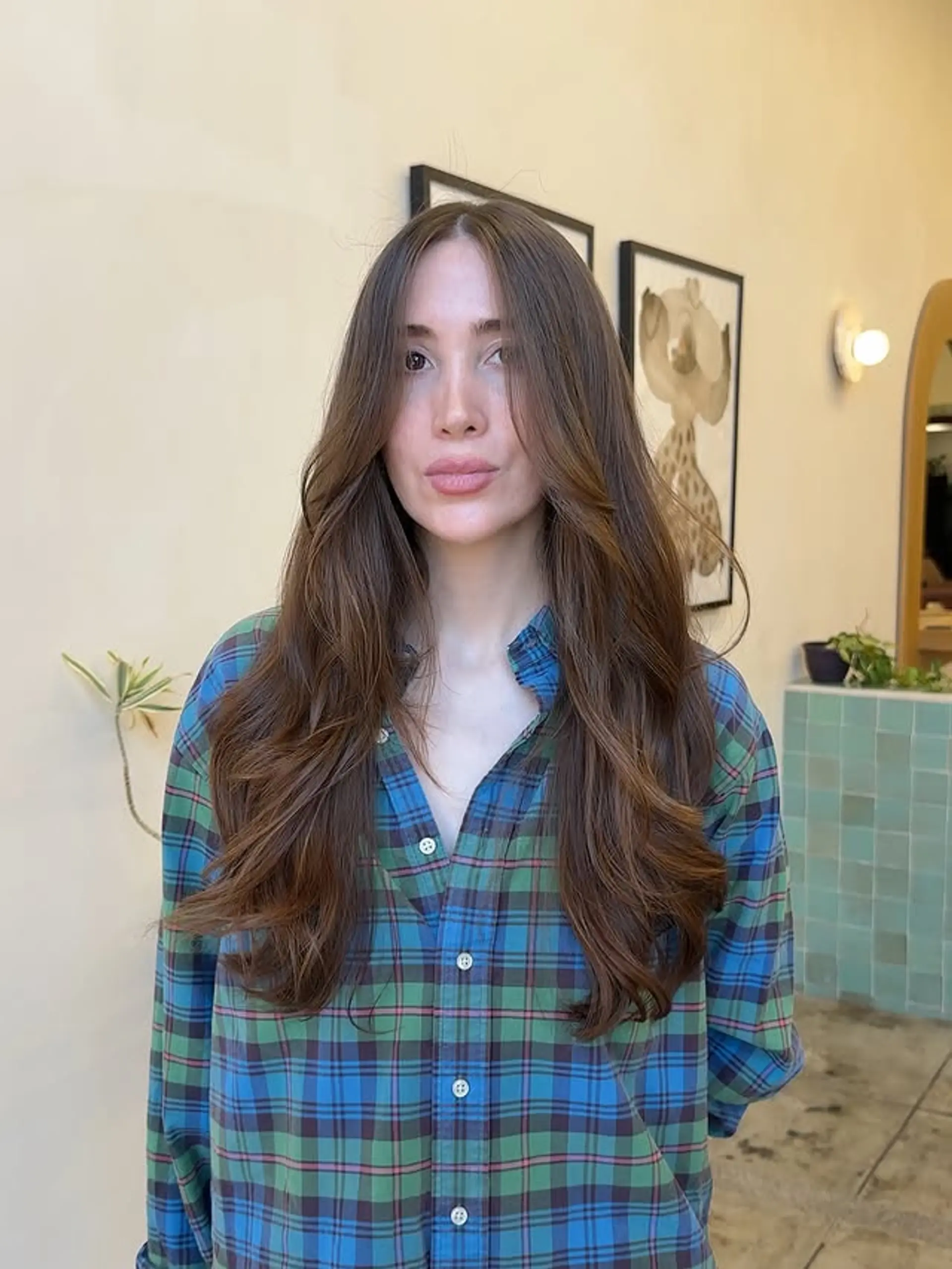 Long, layered hairstyle with soft waves and curtain bangs. 1