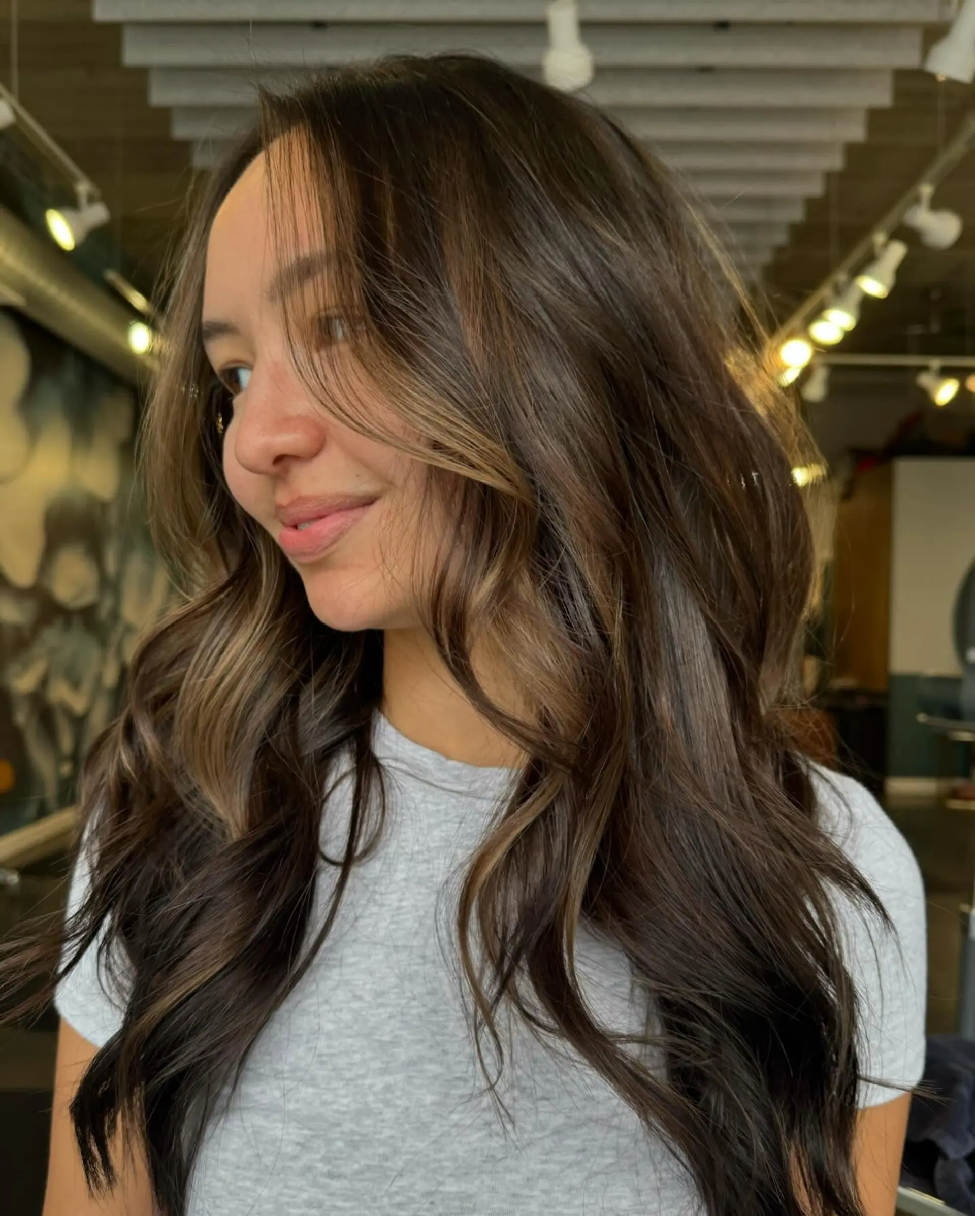 Long, wavy hairstyle with layers and balayage highlights. 1