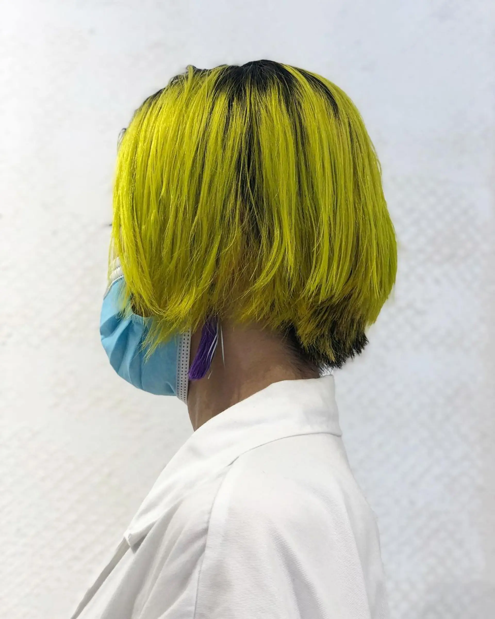 A striking, layered bob with vibrant bright yellow colors contrasting boldly against dark black roots, featuring precise edges. 1