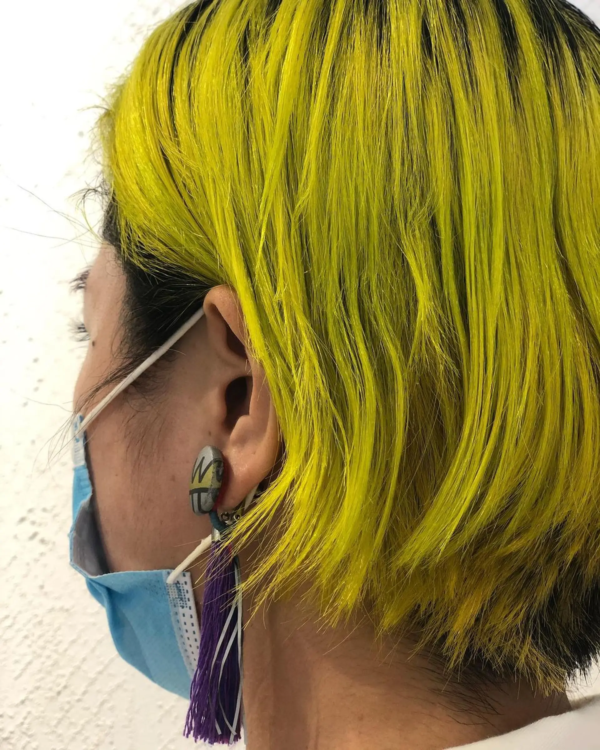 A striking, layered bob with vibrant bright yellow colors contrasting boldly against dark black roots, featuring precise edges. 2