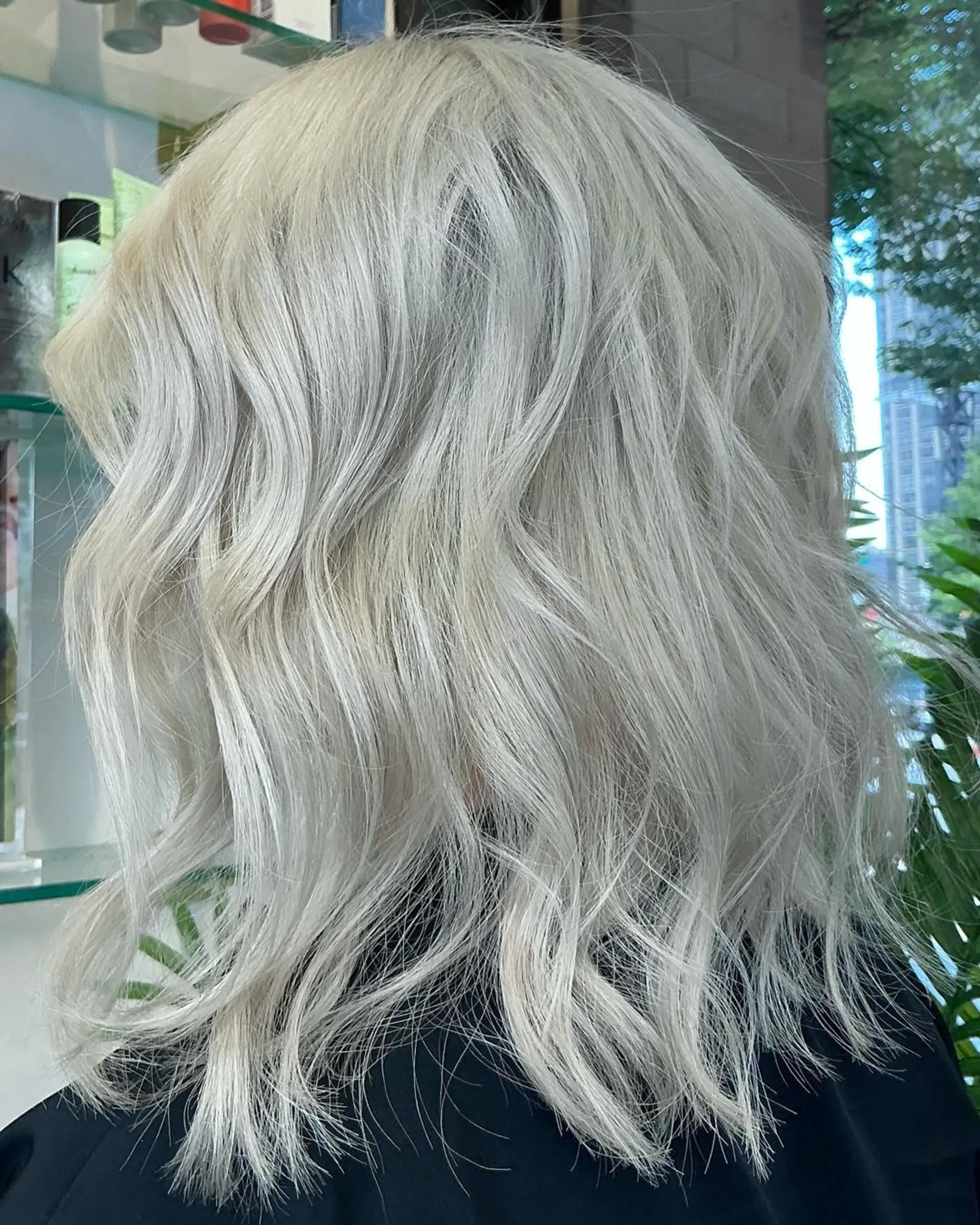 Medium-length platinum blonde hair with soft, textured waves and luminescent shine, featuring natural flow and soft layers. 2